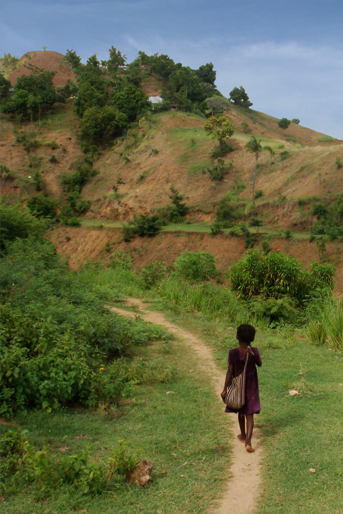 A girl walks along a path on her way to school in the upper watershed of Les Anglais. Until recently, there had been no maps showing where the schools are located, how many students attended, or any other critical information for improving schools facilities.