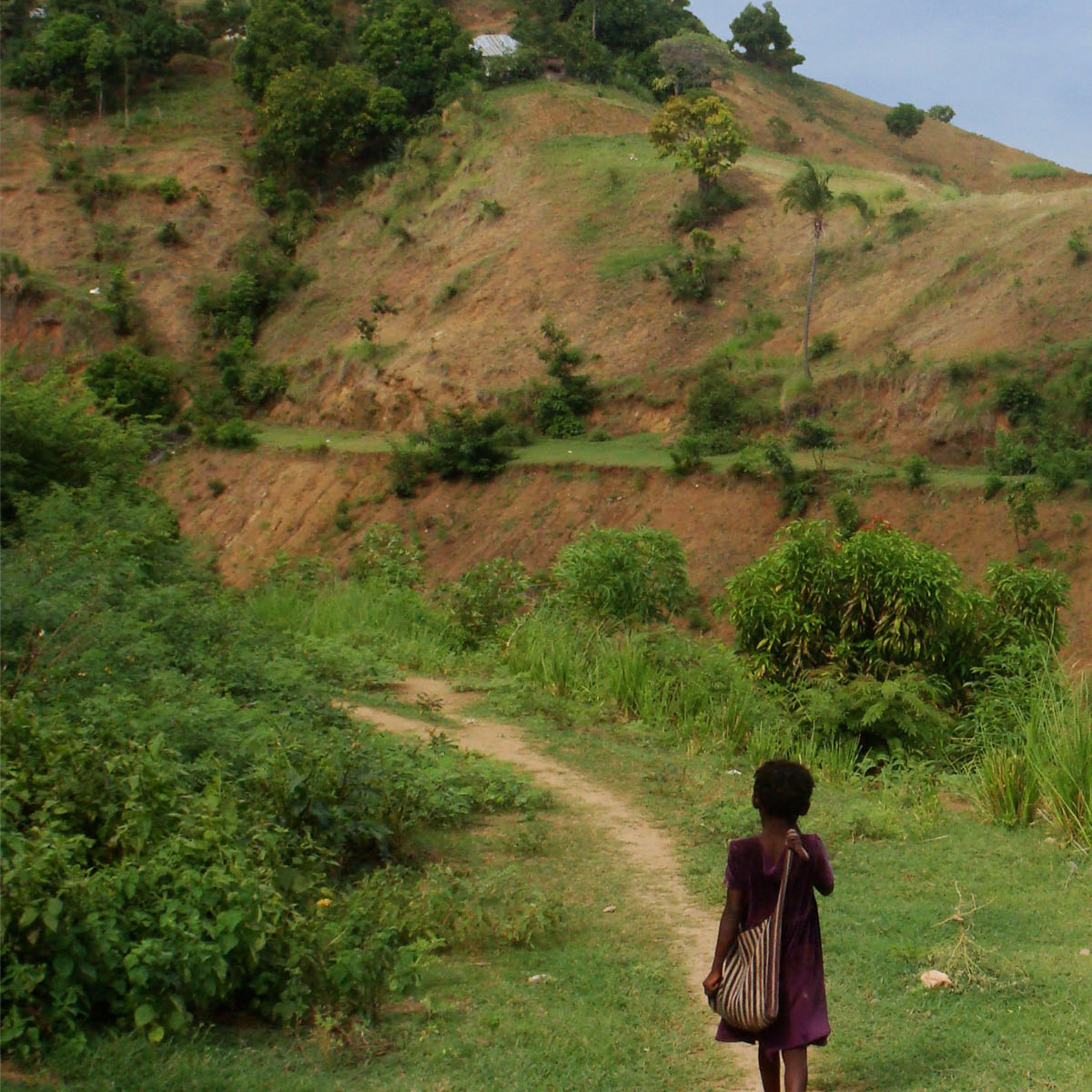 A girl walks along a path on her way to school in the upper watershed of Les Anglais. Until recently, there had been no maps showing where the schools are located, how many students attended, or any other critical information for improving schools facilities.