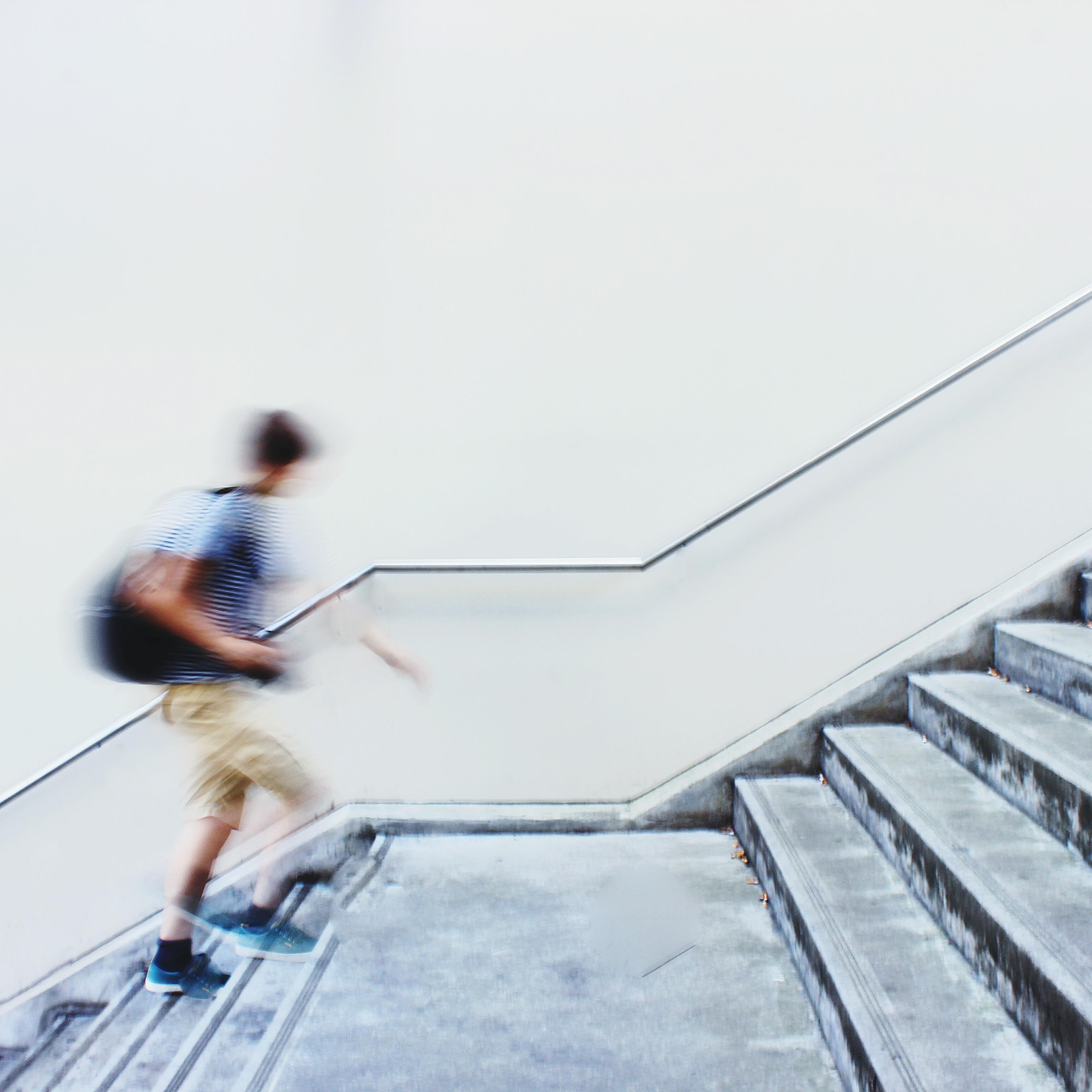 Blurred Motion Of Man Moving Up Staircase