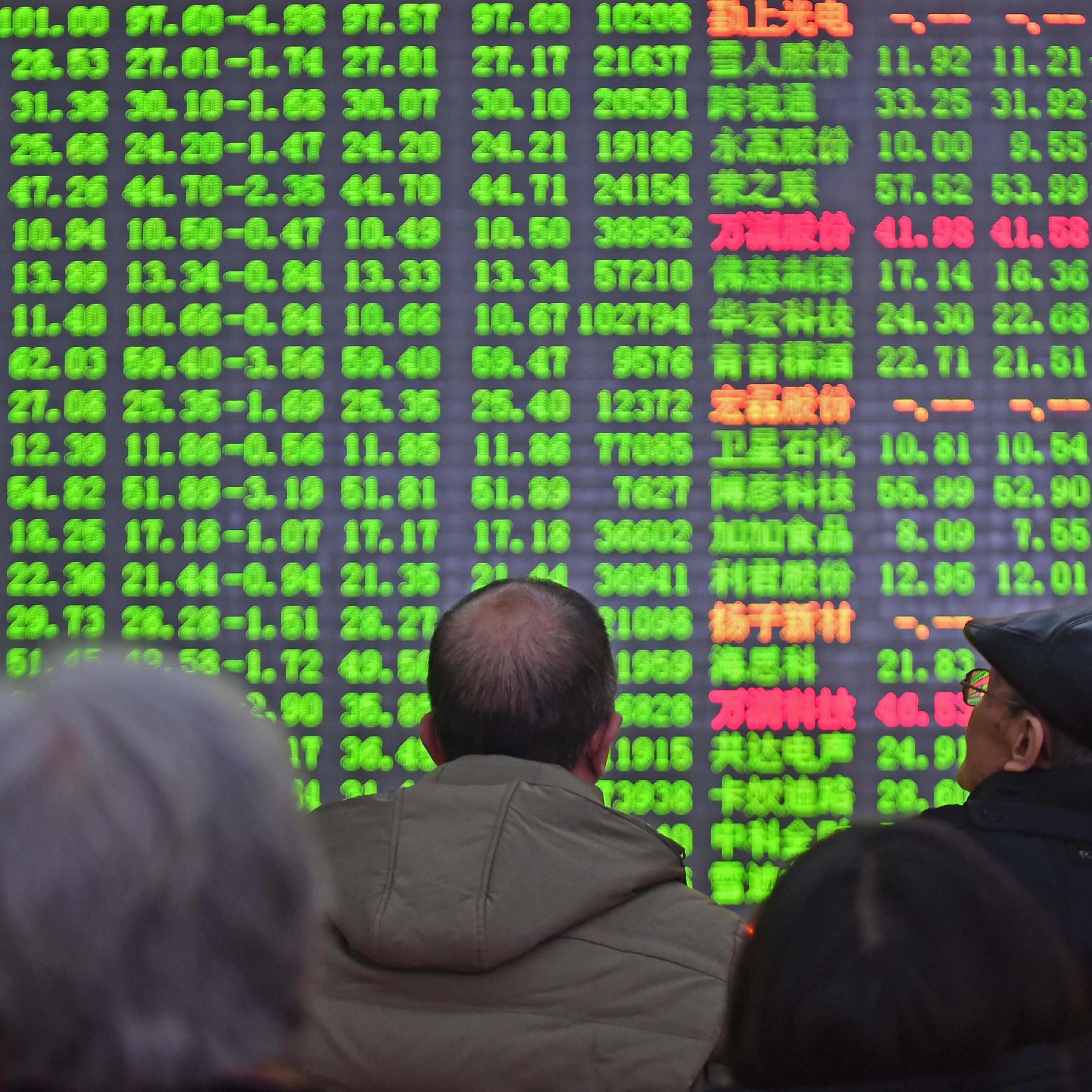 Investors look through stock information at a trading hall in Shenyang, China on Jan. 4, 2016.