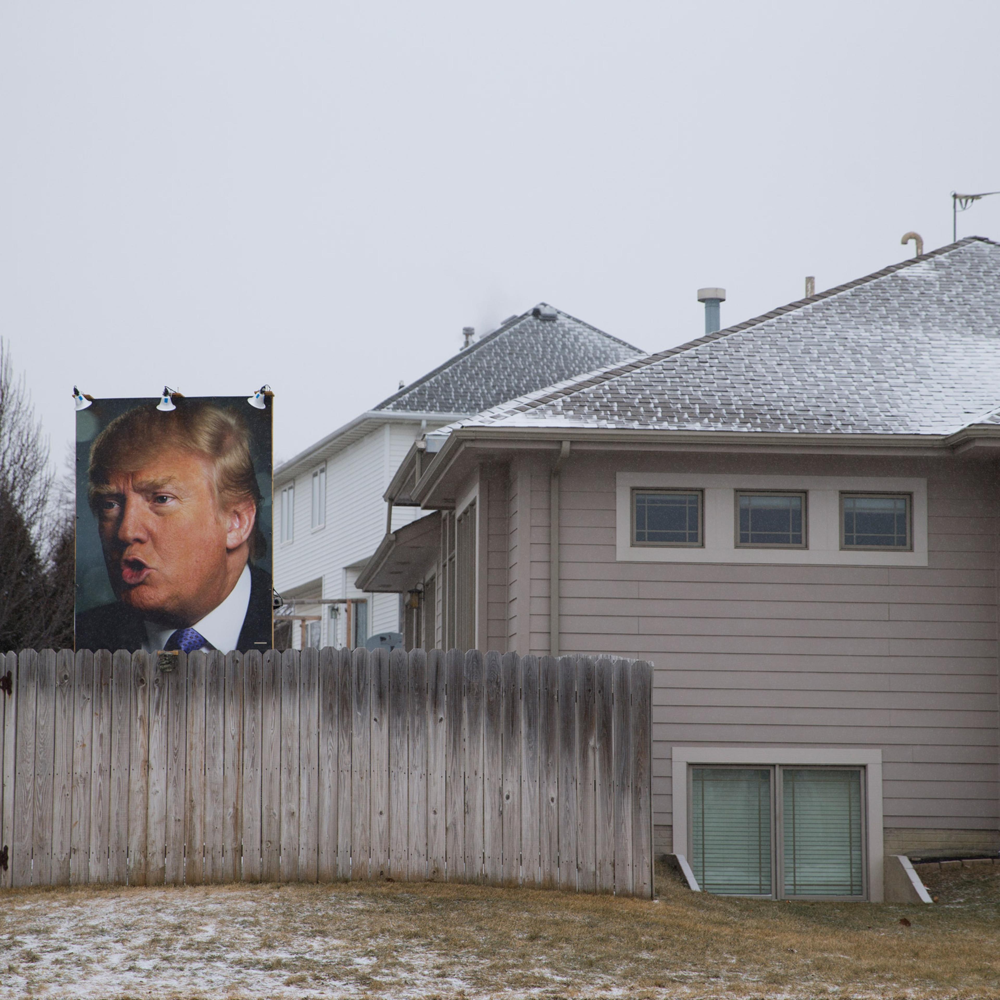A photo of Republican presidential candidate Donald Trump hangs outside a home Tuesday, Jan. 19, 2016, in West Des Moines, Iowa. (AP Photo/Jae C. Hong)