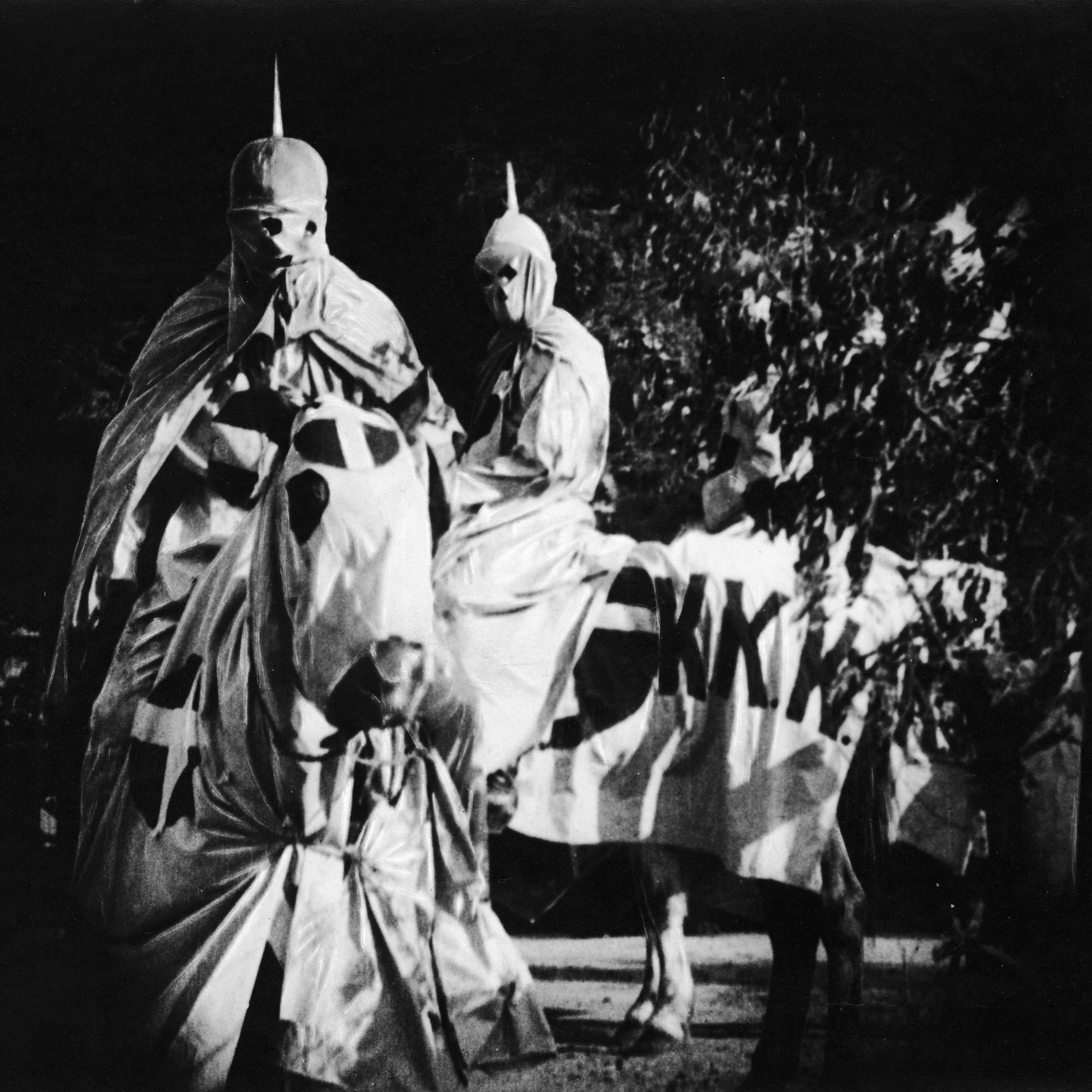 Actors costumed in the full regalia of the Ku Klux Klan ride on horses at night in a still from the 'The Birth of a Nation,' directed by D. W. Griffith, California, 1914.