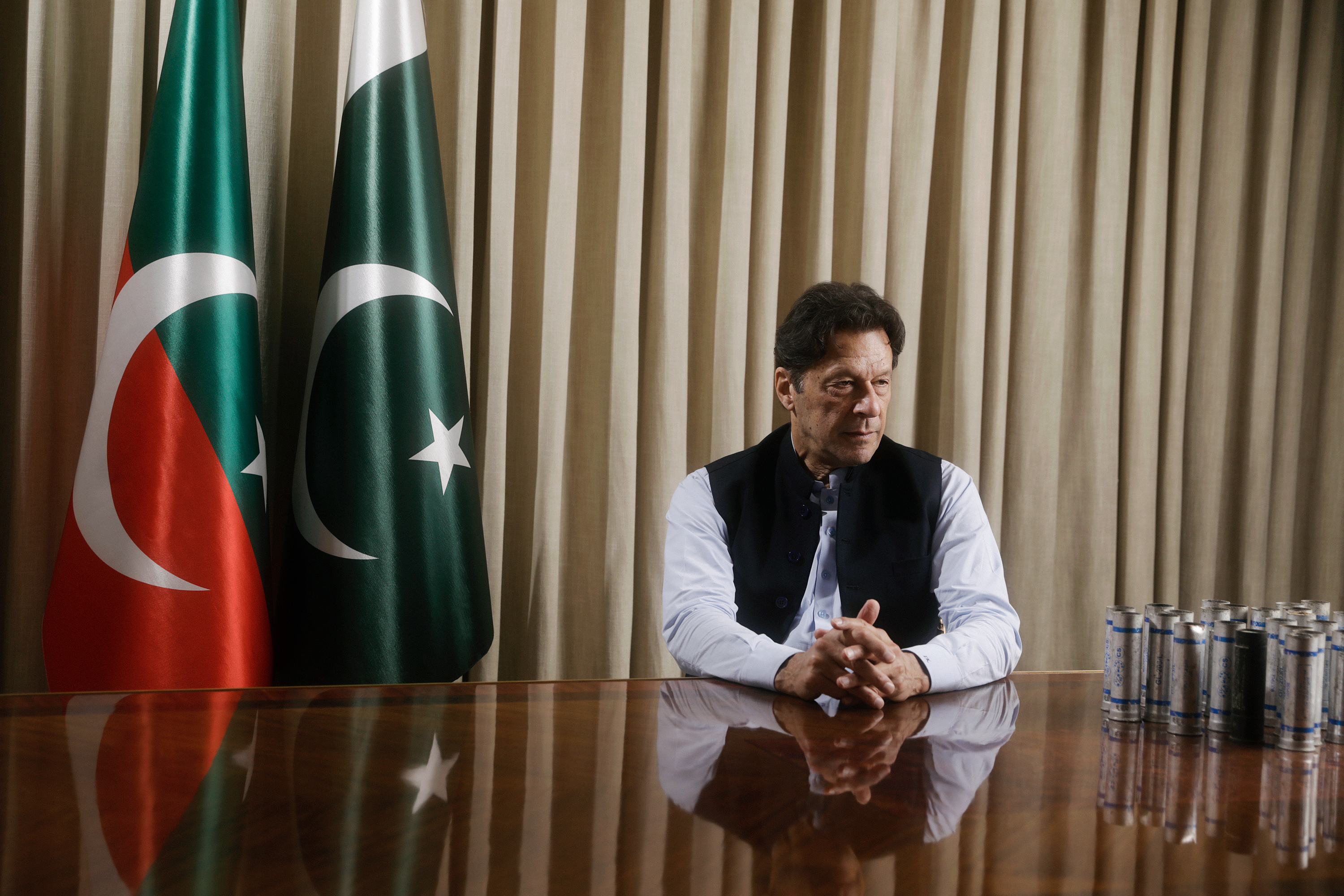 Former Pakistan Prime Minister Imran Khan sits for a portrait in his Lahore residence on March 28. Next to Khan are tear gas canisters he says were thrown at his house. 