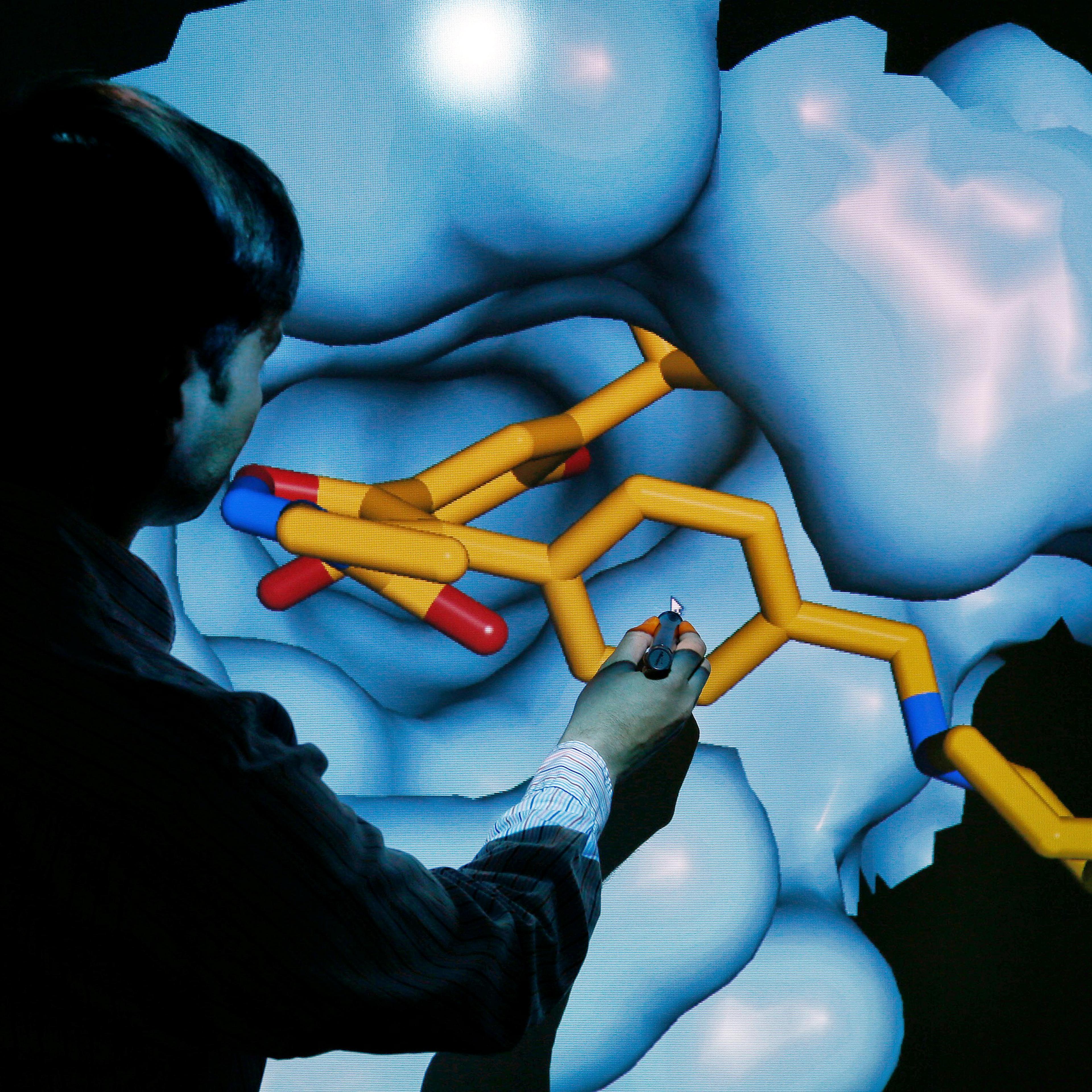Scientist Brown moves a 3D model of a HSP90 protein on a screen at the Institute of Cancer Research in Sutton
