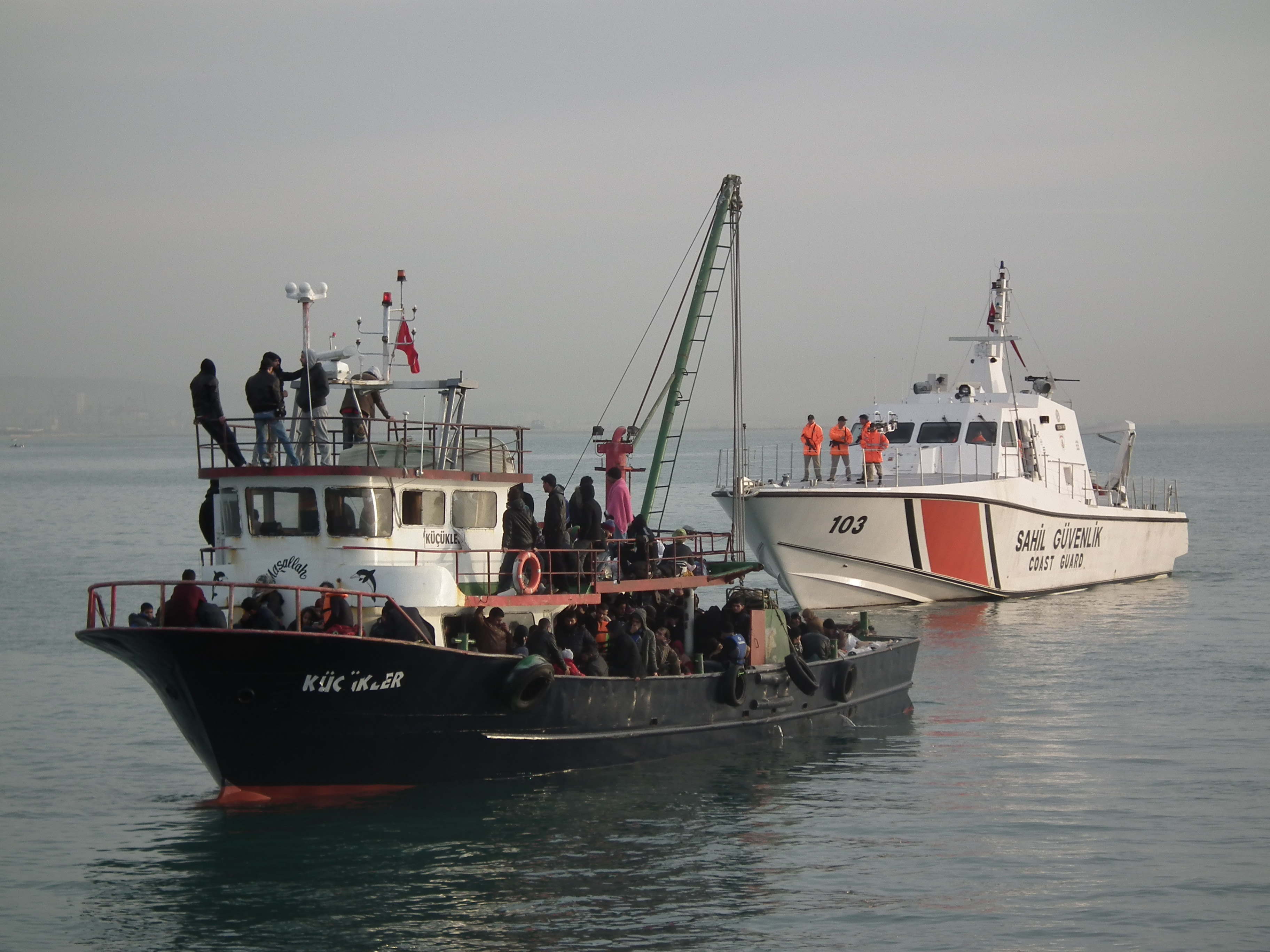 MERSIN, TURKEY - DECEMBER 06:  Illegal immigrants are escorted by the officers of Turkey's Coast Guard Mediterranean Region Command as they arrive in Mersin, Turkey on December 06, 2014. Some 361 illegal migrants and six organizers of the illegal crossin