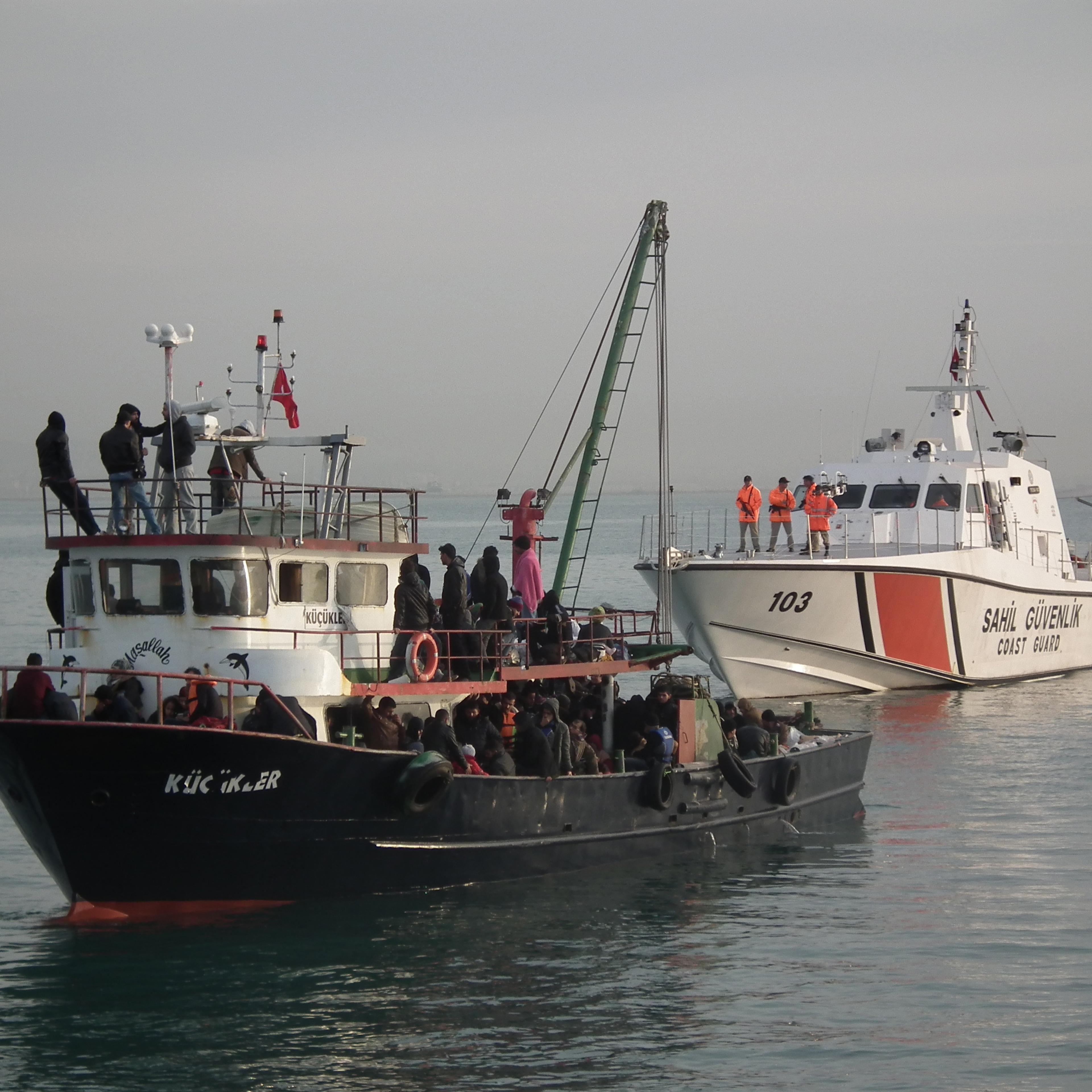 MERSIN, TURKEY - DECEMBER 06: Illegal immigrants are escorted by the officers of Turkey's Coast Guard Mediterranean Region Command as they arrive in Mersin, Turkey on December 06, 2014. Some 361 illegal migrants and six organizers of the illegal crossin