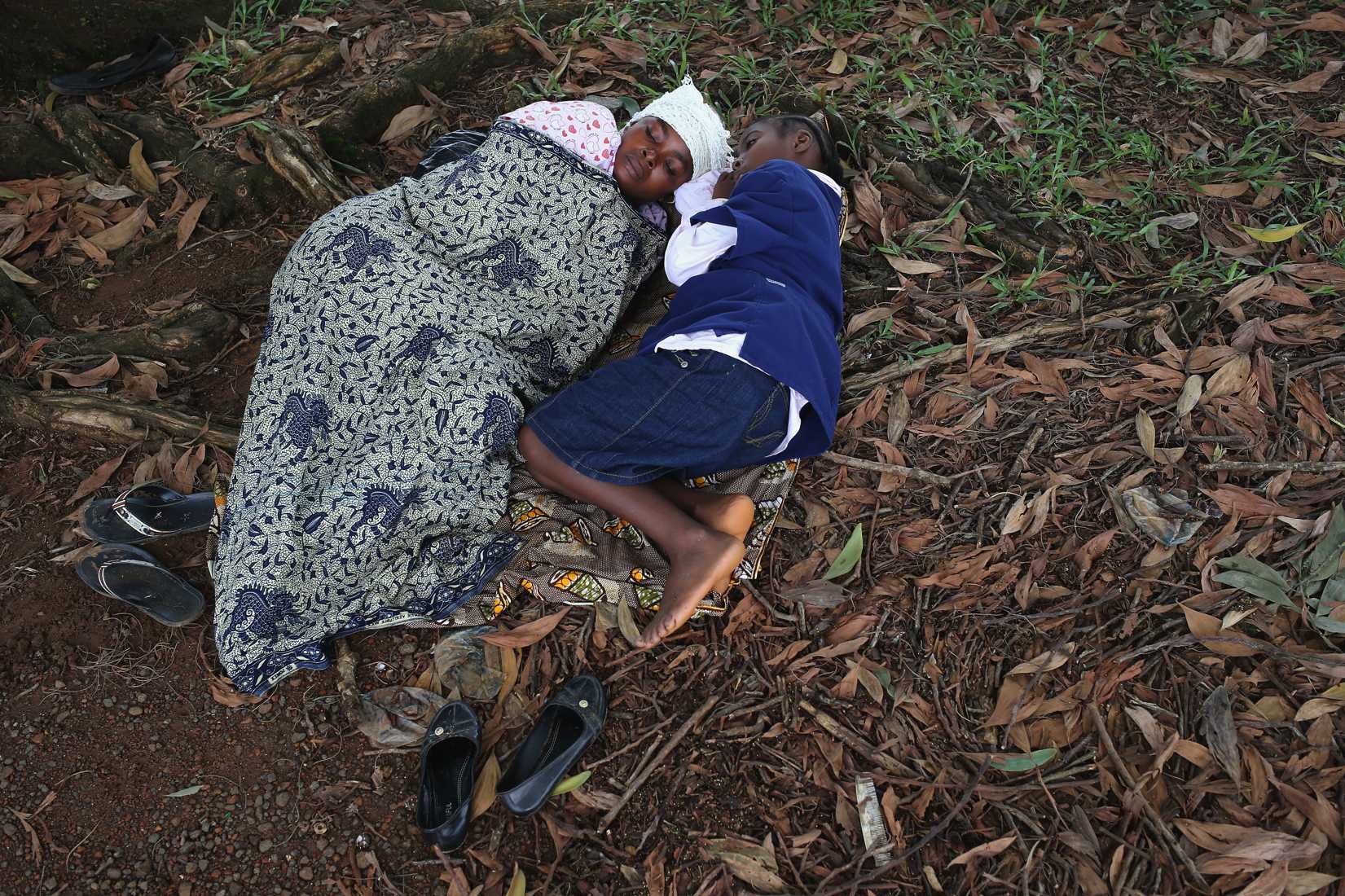 Hanah Siafa lies with her daughter Josephine, 10, while hoping to enter the new Doctors Without Borders (MSF), Ebola treatment center on August 17, 2014 in Monrovia, Liberia.
