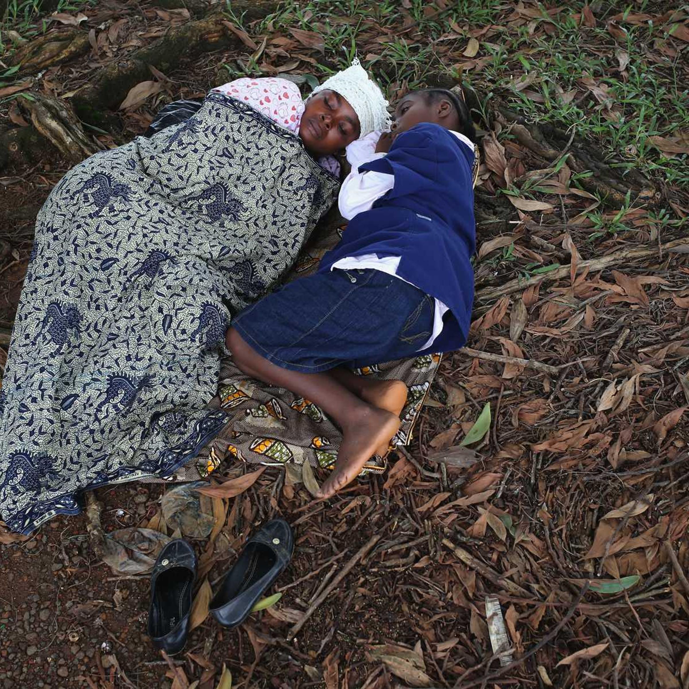 Hanah Siafa lies with her daughter Josephine, 10, while hoping to enter the new Doctors Without Borders (MSF), Ebola treatment center on August 17, 2014 in Monrovia, Liberia.