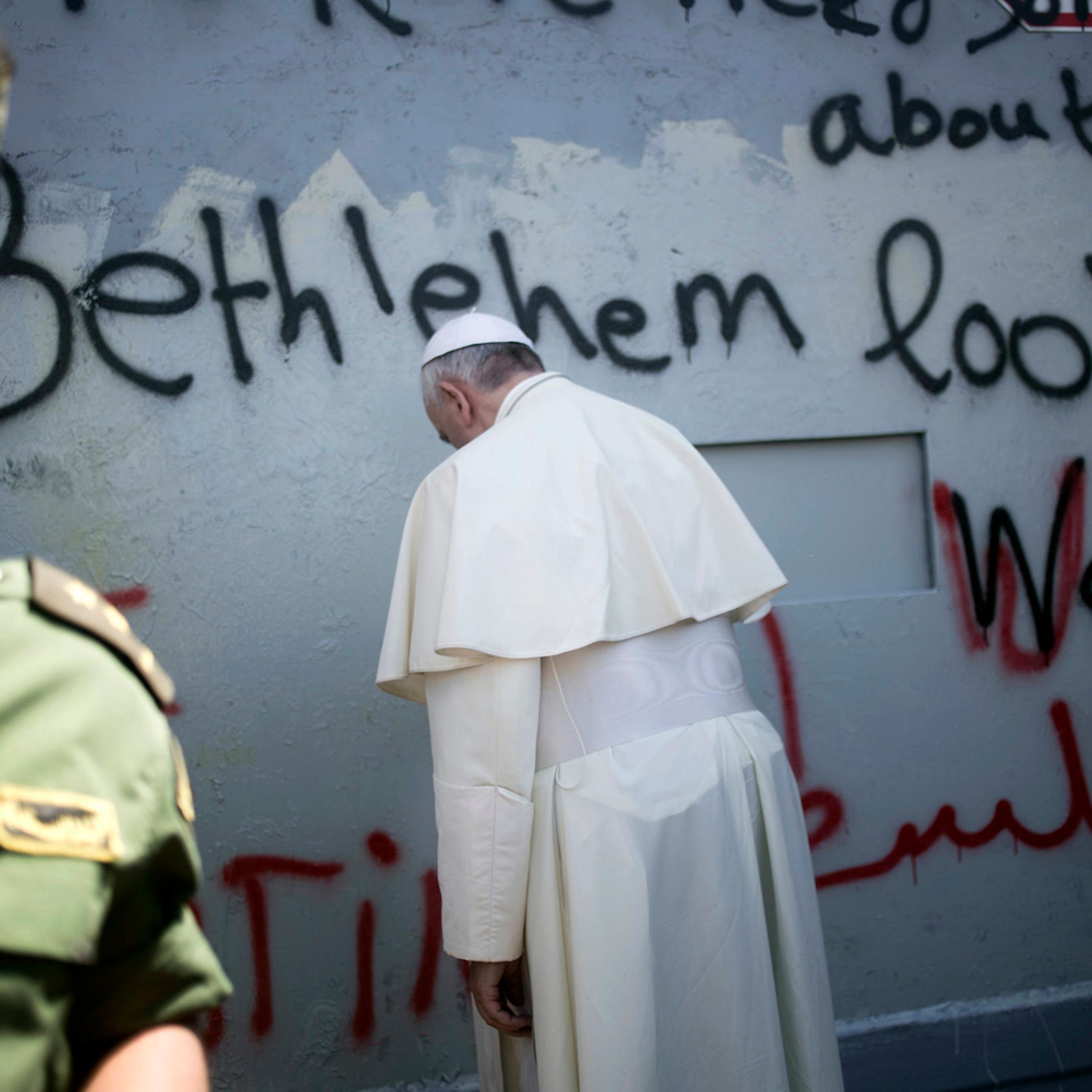 Pope Francis prays at Israel's separation barrier on his way to a mass in Manger Square next to the Church of the Nativity, traditionally believed to be the birthplace of Jesus Christ, in the West Bank town of Bethlehem on May 25, 2014.