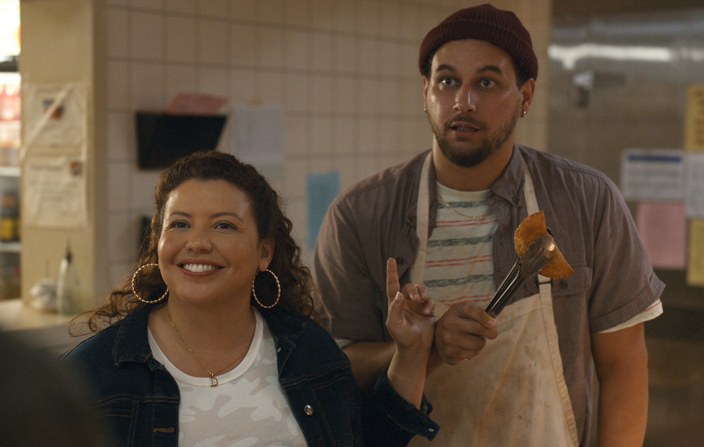 Dolores Roach (Justina Machado) shushes Luis (Alejandro Hernandez), the overzealous owner of Empanada Loca.