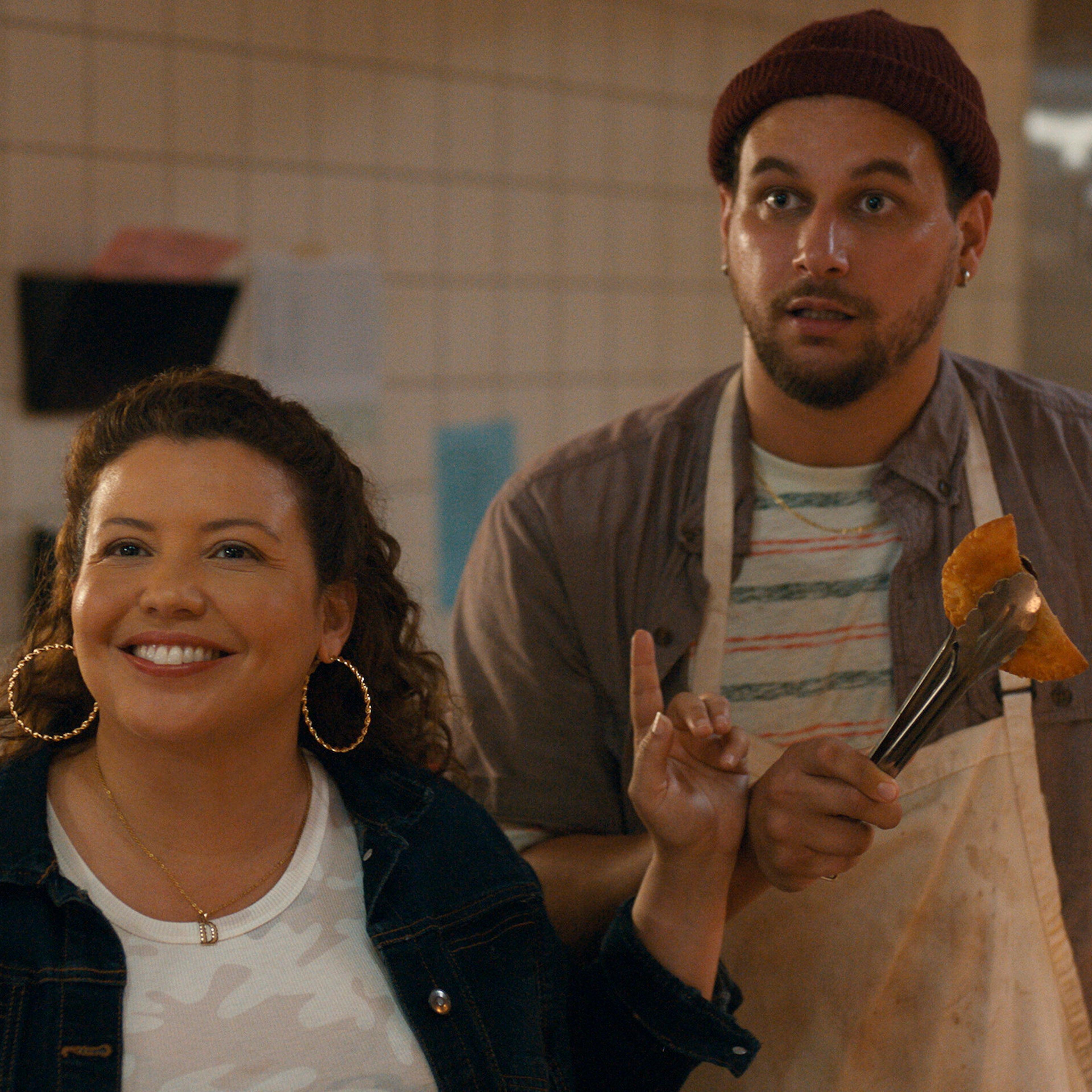 Dolores Roach (Justina Machado) shushes Luis (Alejandro Hernandez), the overzealous owner of Empanada Loca.