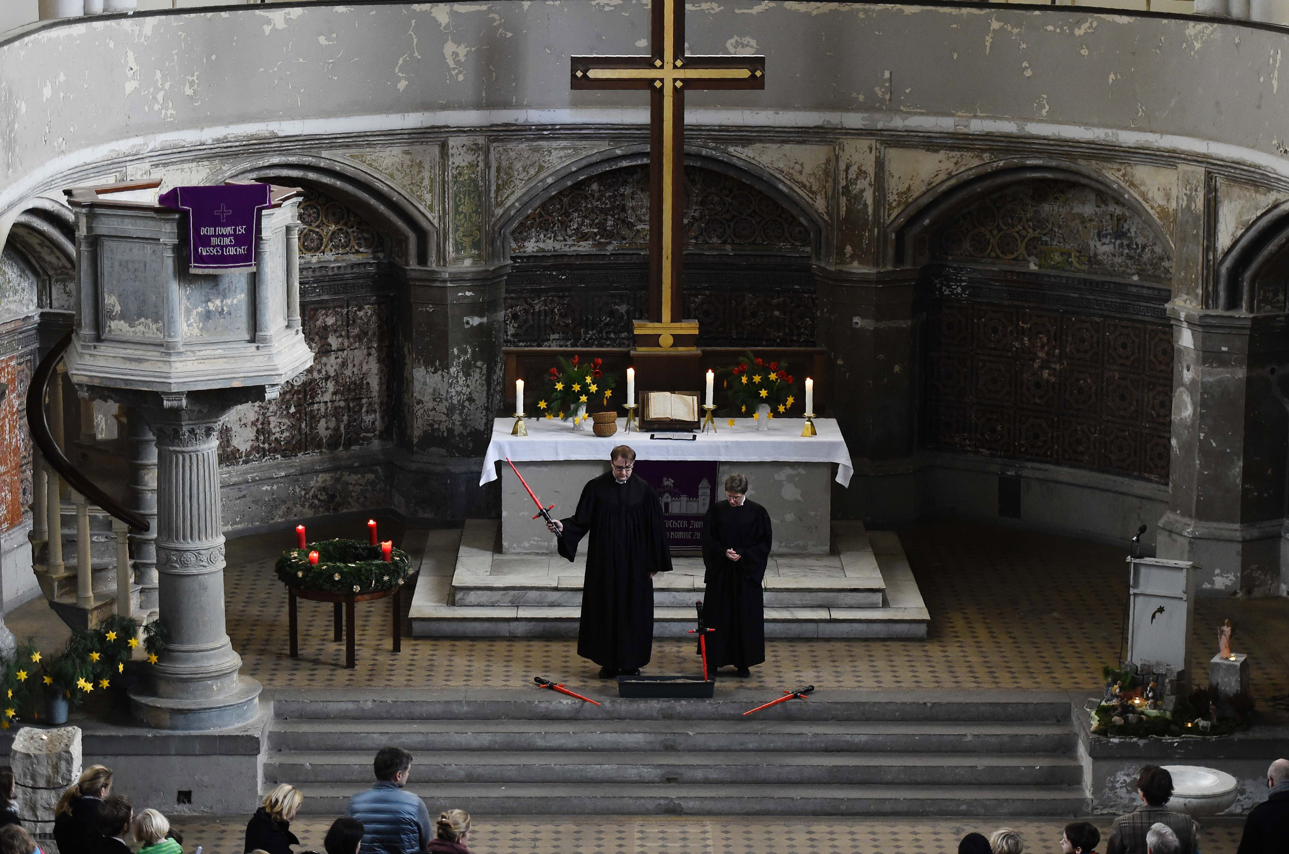 Vicar Lucas Ludewig holds up a toy saber next to vicar Ulrike Garve inside the zion church during a Star Wars-themed service in Berlin on Dec. 20, 2015.