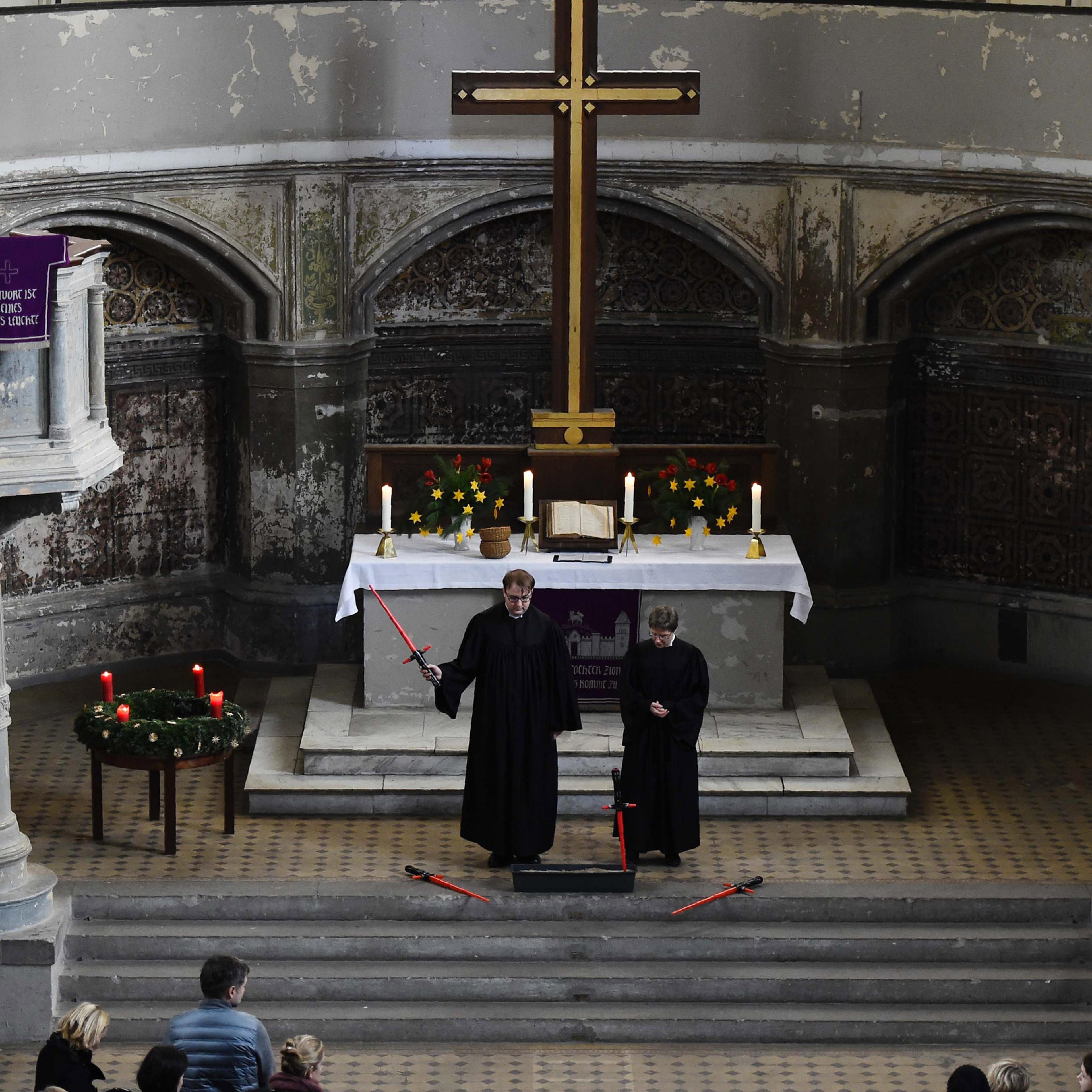 Vicar Lucas Ludewig holds up a toy saber next to vicar Ulrike Garve inside the zion church during a Star Wars-themed service in Berlin on Dec. 20, 2015.