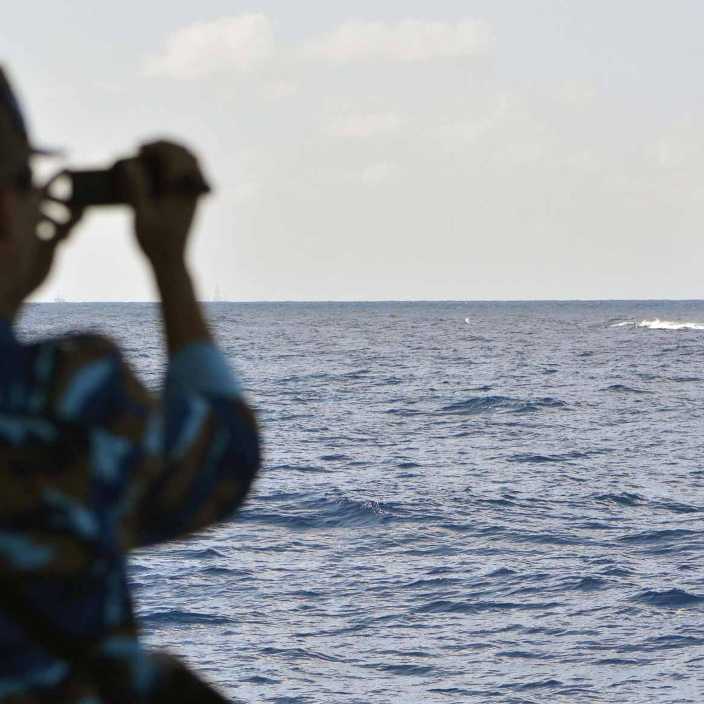 South China Sea, a crew member of a Vietnamese coast-guard vessel monitors the movements of a Chinese patrol ship