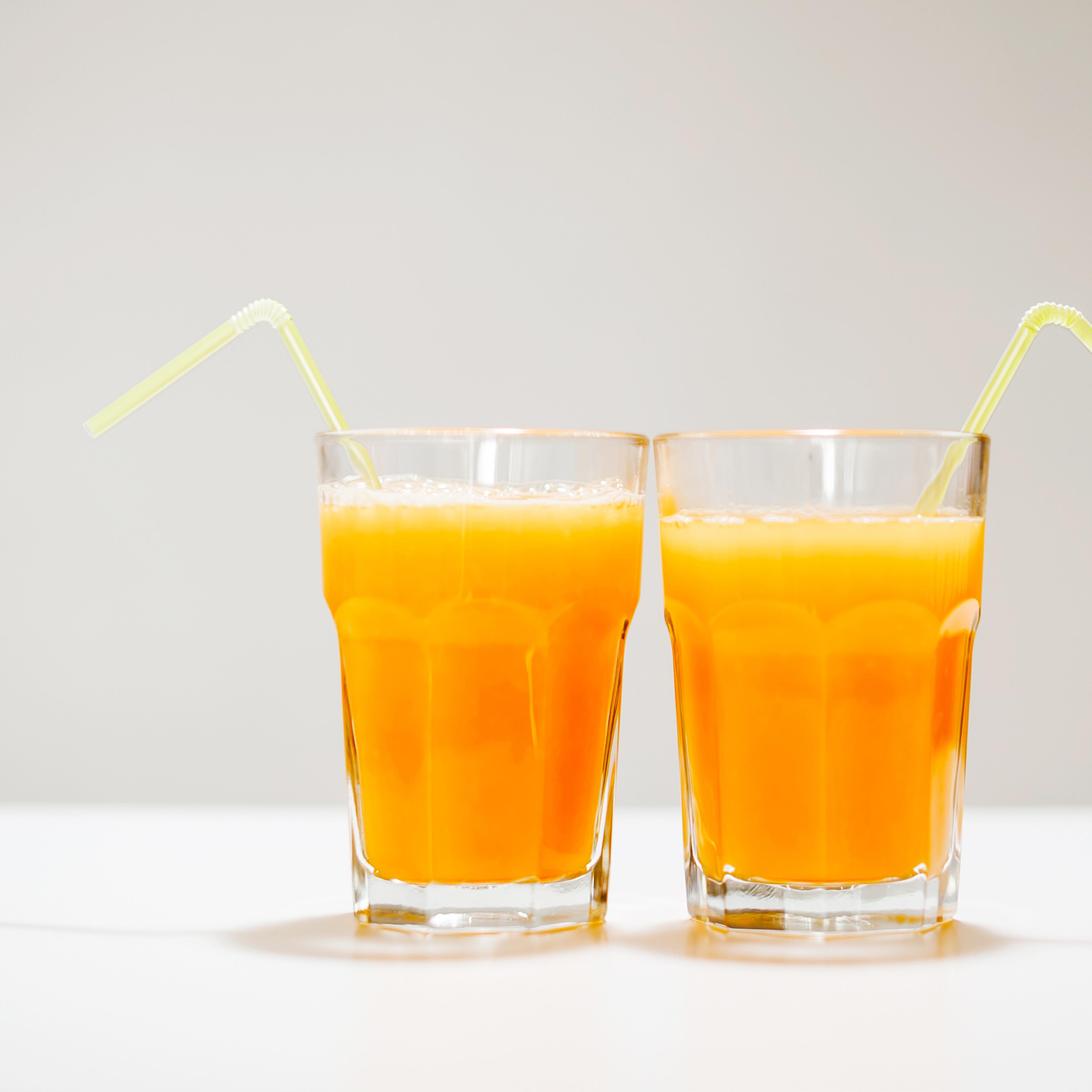Two glass of orange juice with straw
