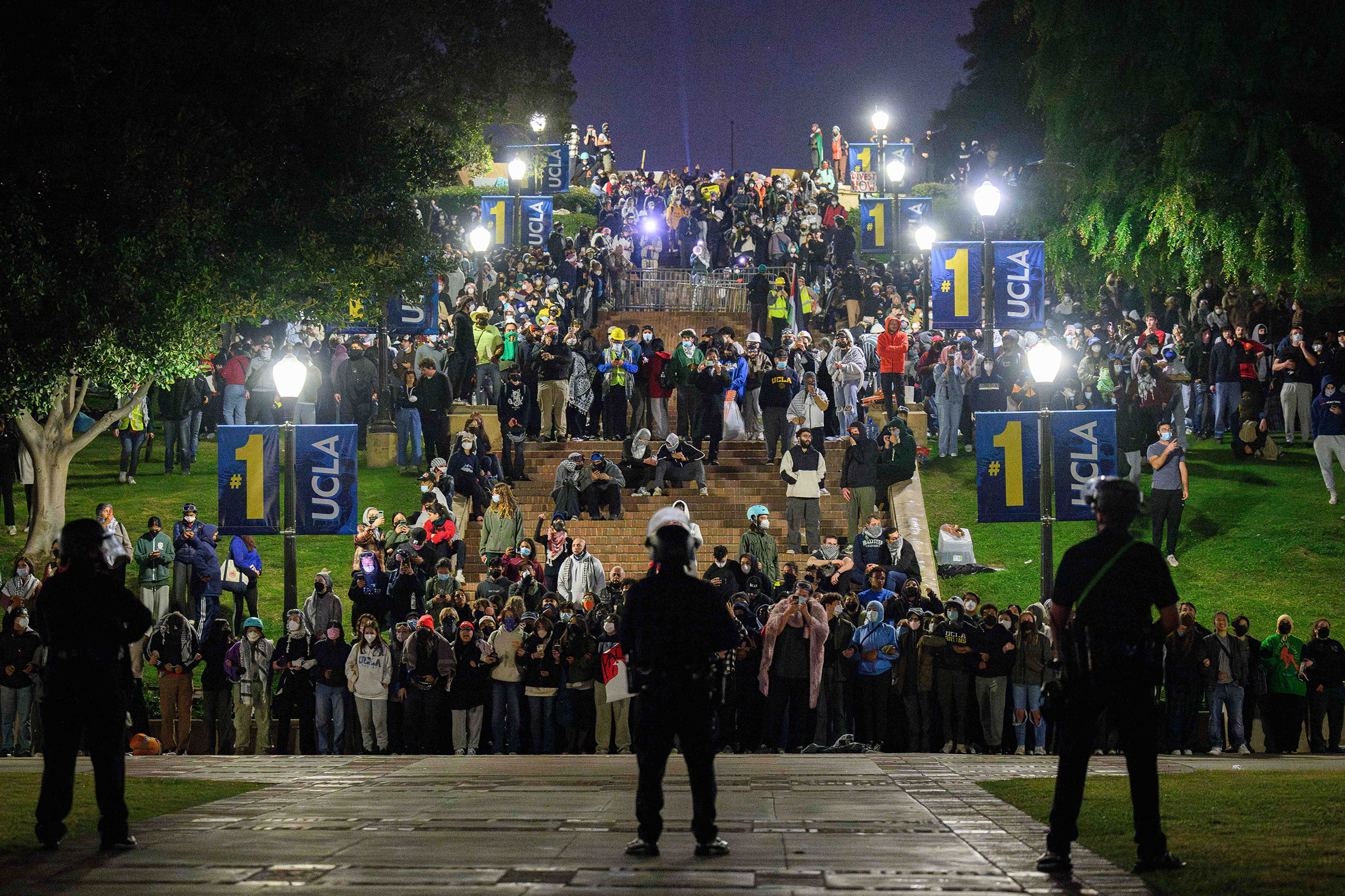 Pro-Palestine supporters link arms on Janss Steps at UCLA while facing police officers in the early hours of May 2. The Palestine solidarity encampment was attacked by counterprotesters the day before.