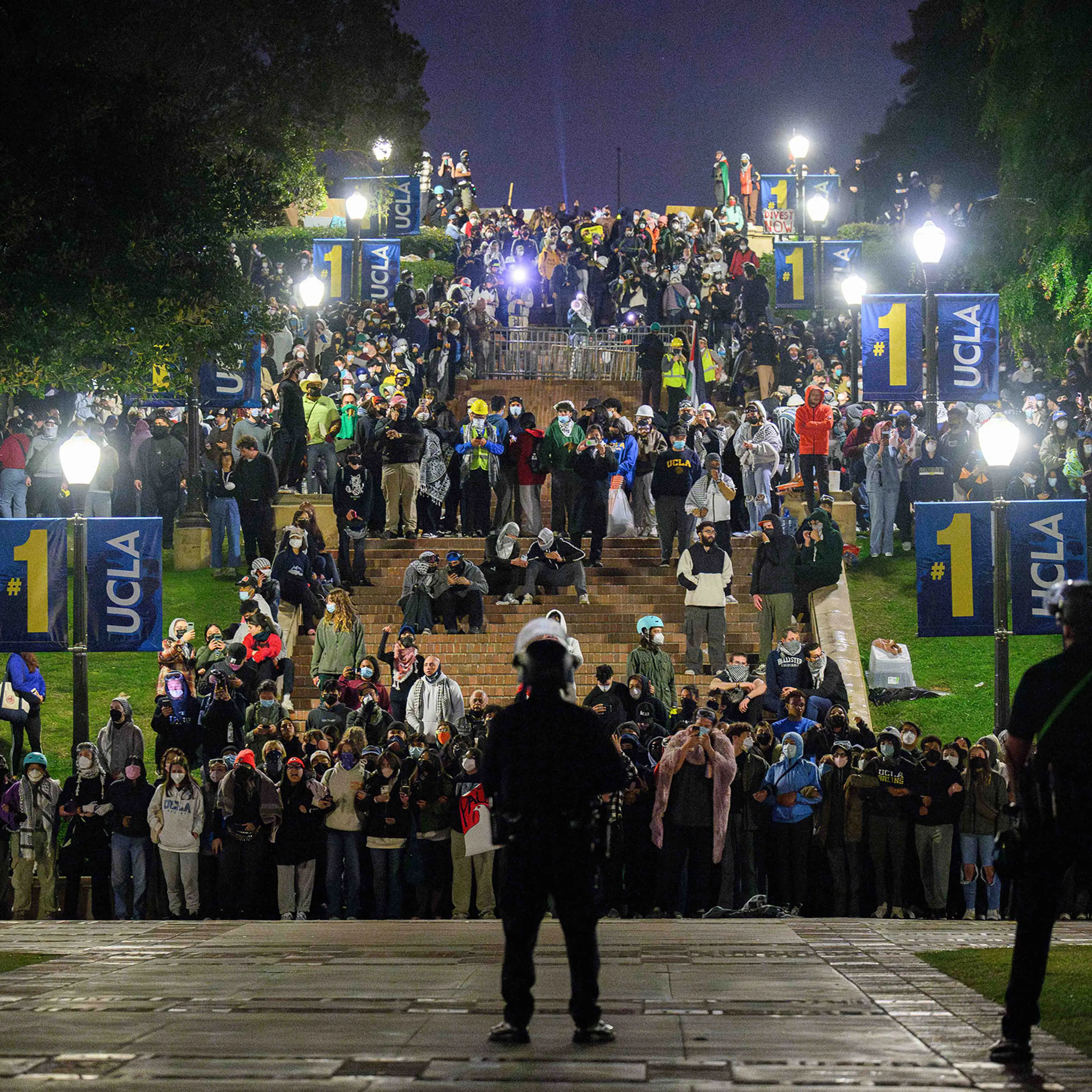 Pro-Palestine supporters link arms on Janss Steps at UCLA while facing police officers in the early hours of May 2. The Palestine solidarity encampment was attacked by counterprotesters the day before.