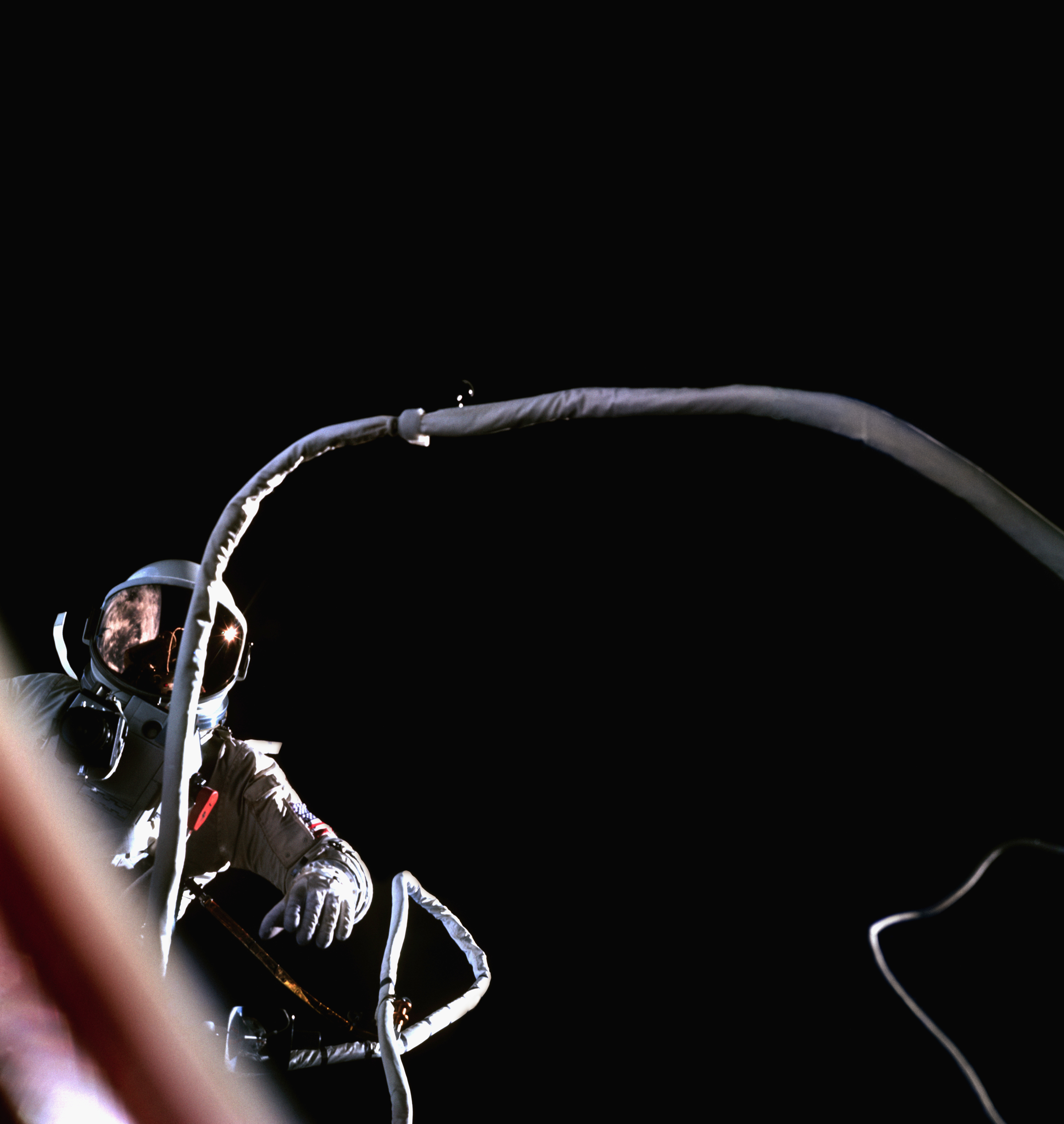 In a view from the Gemini 9 spacecraft, Astronaut Gene Cernan tethered to the Gemini 9 spacecraft as it orbits the Earth.