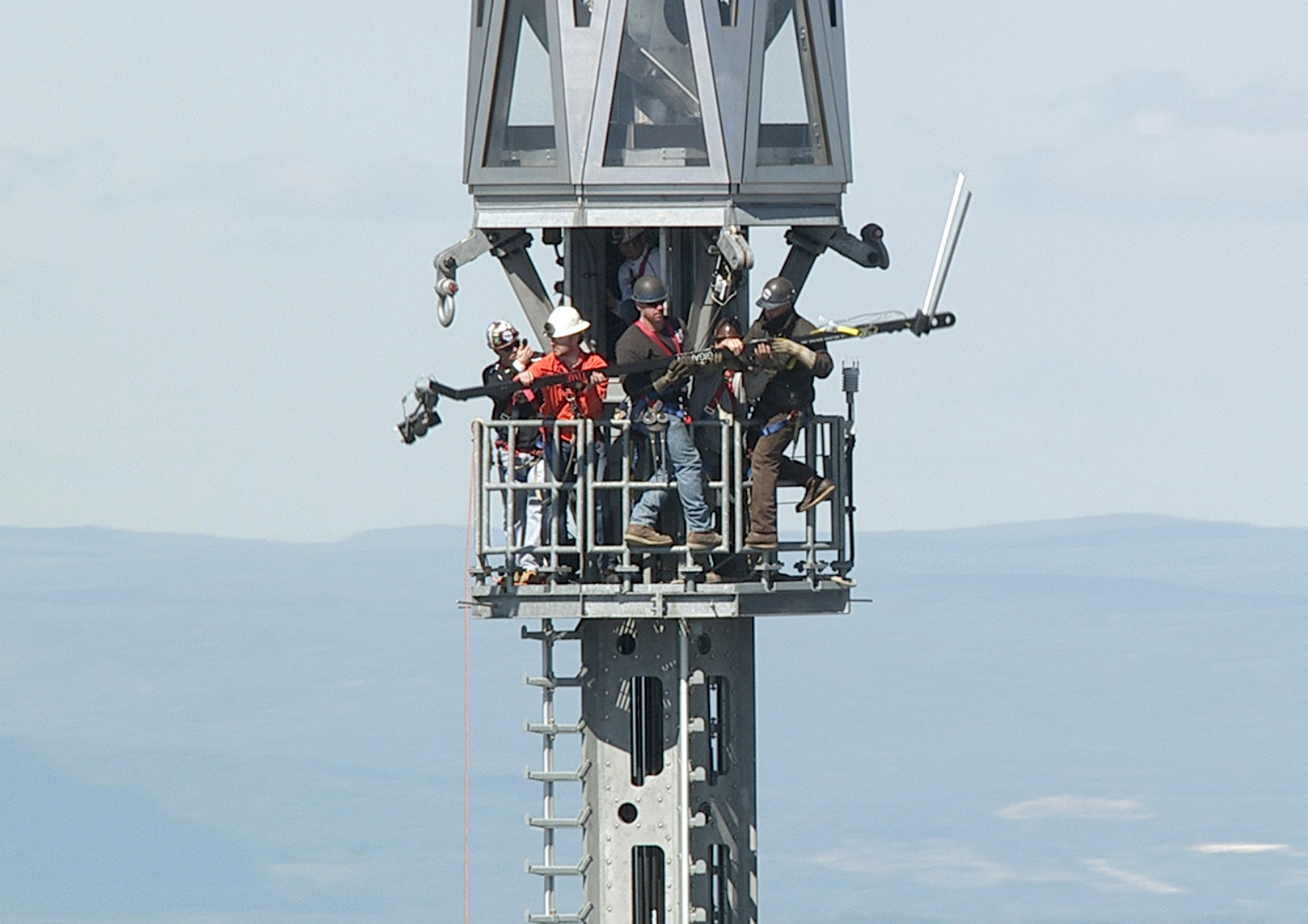 Jonathan Woods (in orange) assists ironworkers as they remove the 13-foot-long jib from the beacon at the very top of 1 World Trade Center in New York City on Sept. 28, 2013.