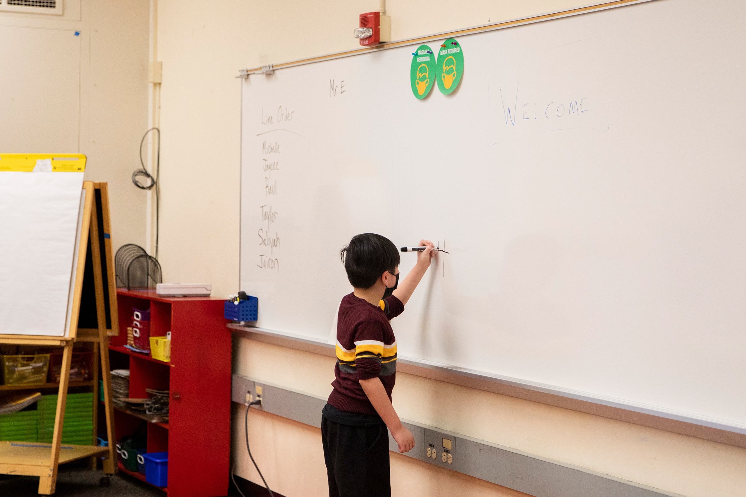 A second-grade student works on a math problem on the board at an elementary school in California. 