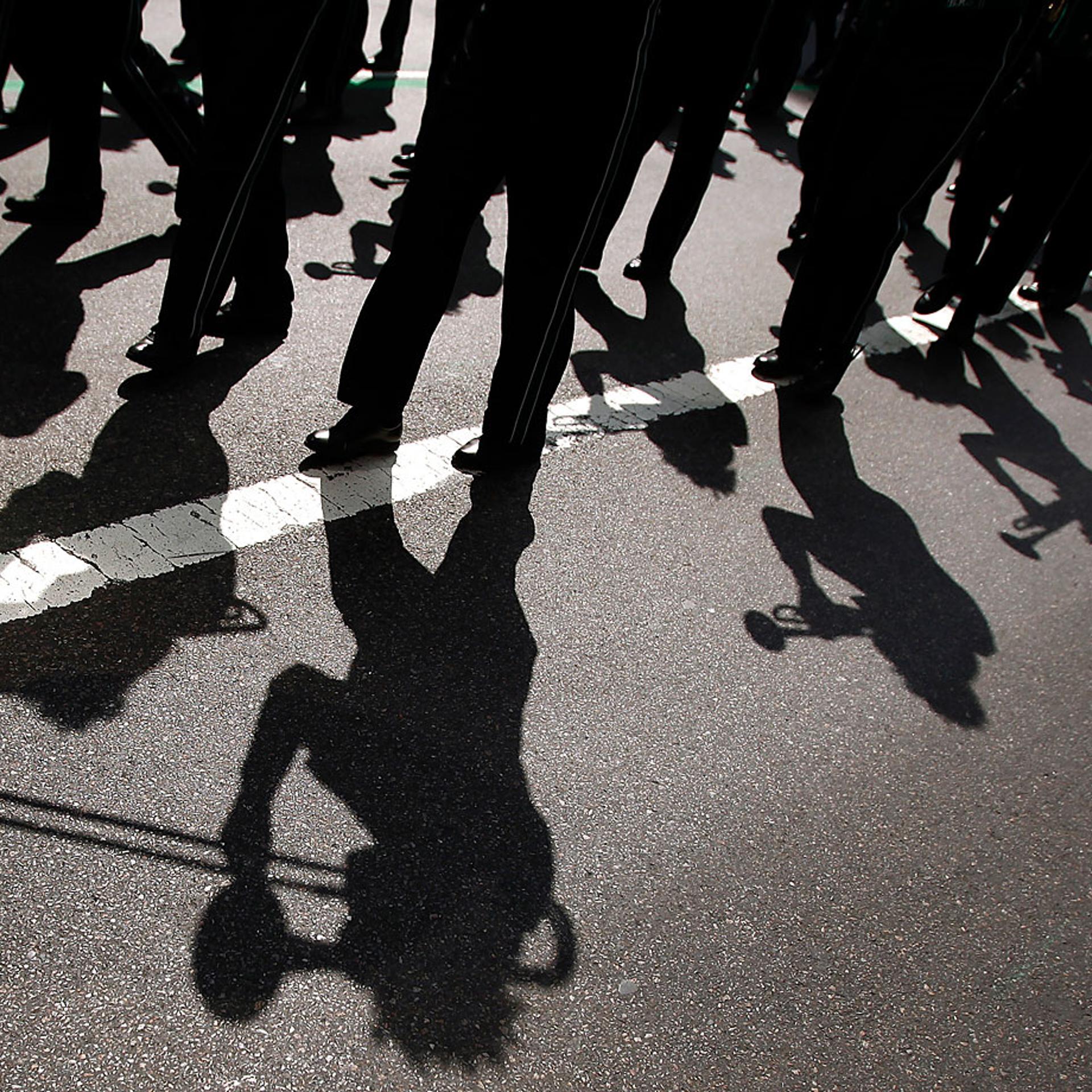 A marching band casts shadows on the road during the 251st annual St. Patrick's Day Parade in New York