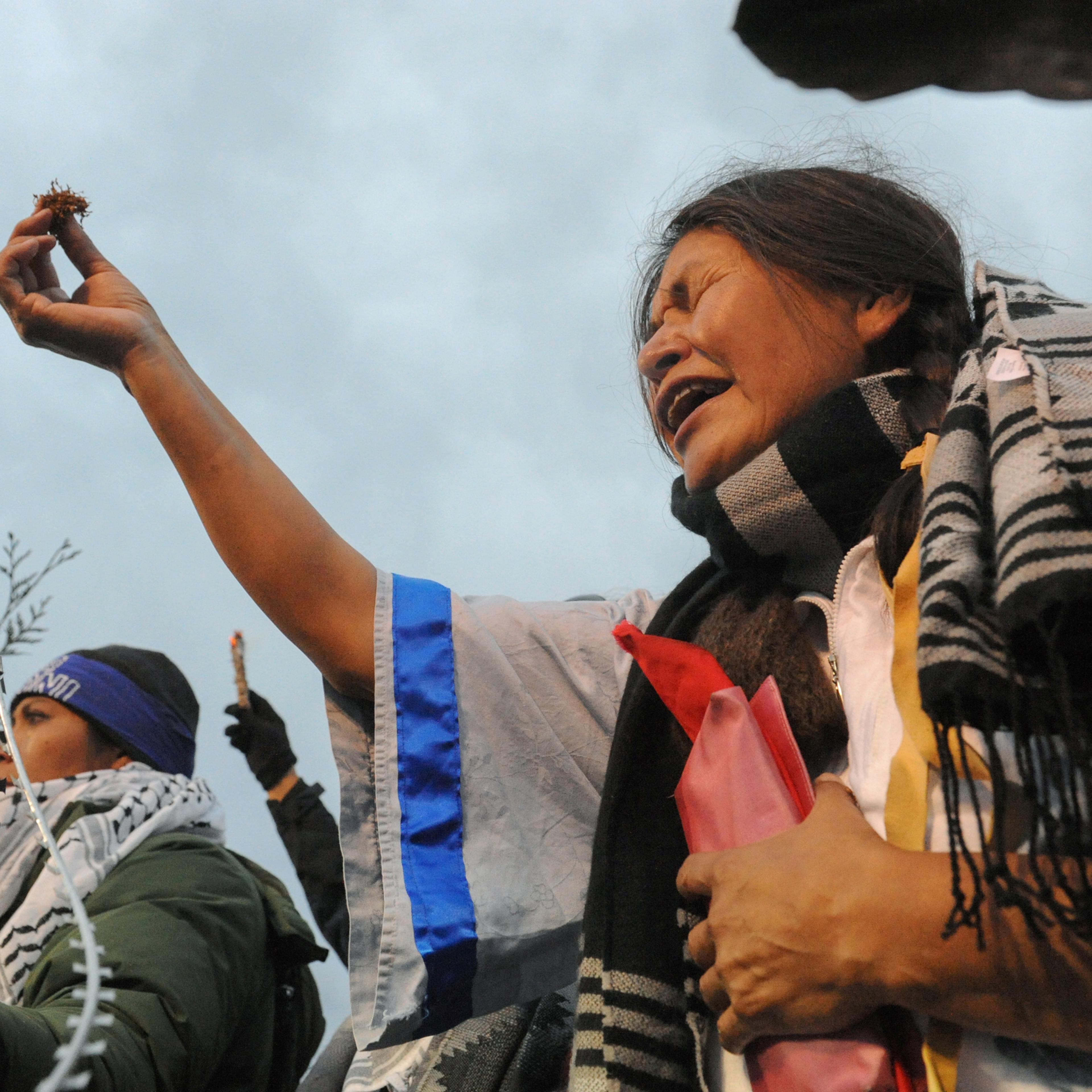 Cheryl Angel offers ceremonial tobacco on Backwater Bridge during a protest against plans to pass the Dakota Access pipeline near the Standing Rock Indian Reservation, near Cannon Ball, North Dakota