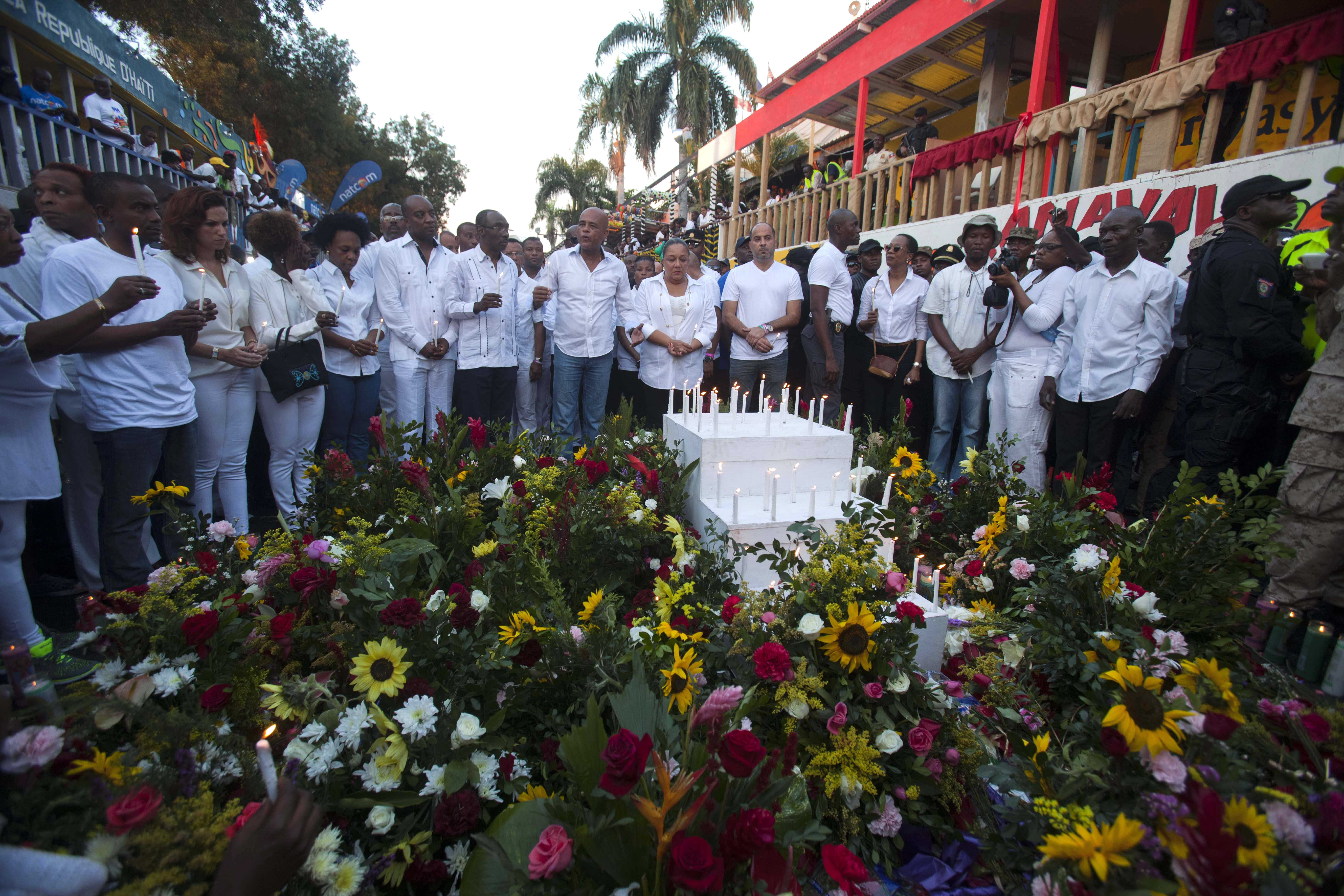 Haiti's President Michel Martelly, center left, and first lady Sophia Martelly, right center, stand at a memorial in Port-au-Prince, Haiti, Feb. 17, 2015