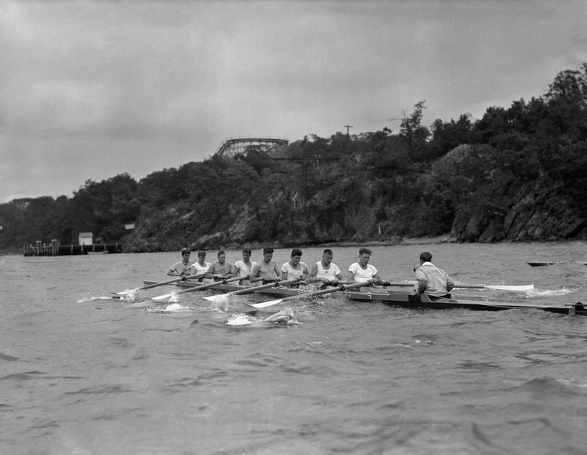 The University of Washington's varsity crew team at the Poughkeepsie Regatta Races in June 1936. Pictured from right to left: Bob Moch, Coxwain; Don Hume, Stroke; Joe Rantz, 7; George Hunt, 6; Jim McMillin, 5; John White, 4; Gordon Adams, 3; Charles Day, 2; and Roger Morris, 1.