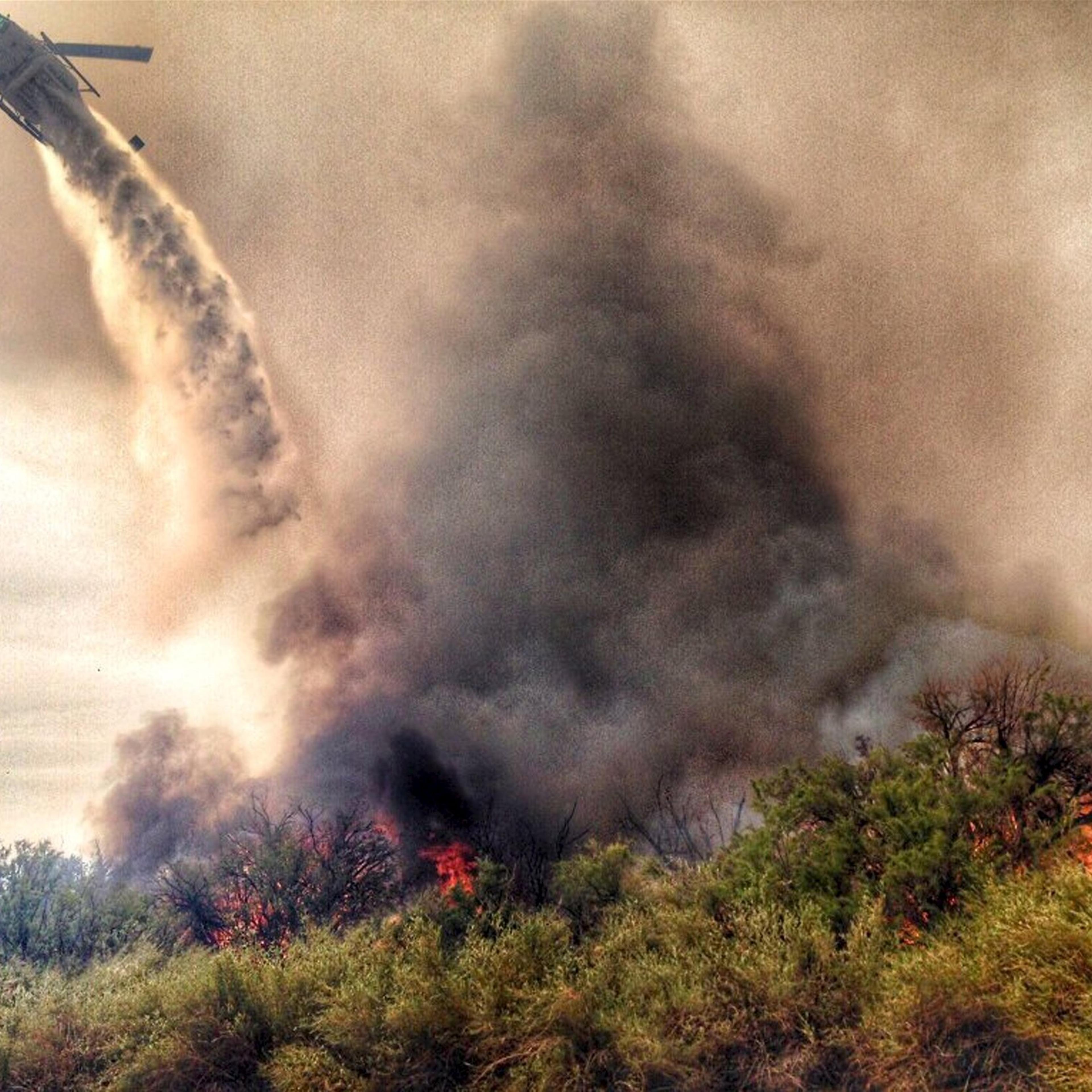 A helicopter makes a drop on a fire which broke out in Arizona and spread into California, sparking the evacuation of two recreational vehicle parks near the Havasu National Wildlife Refuge in Calif. on April 6, 2016.