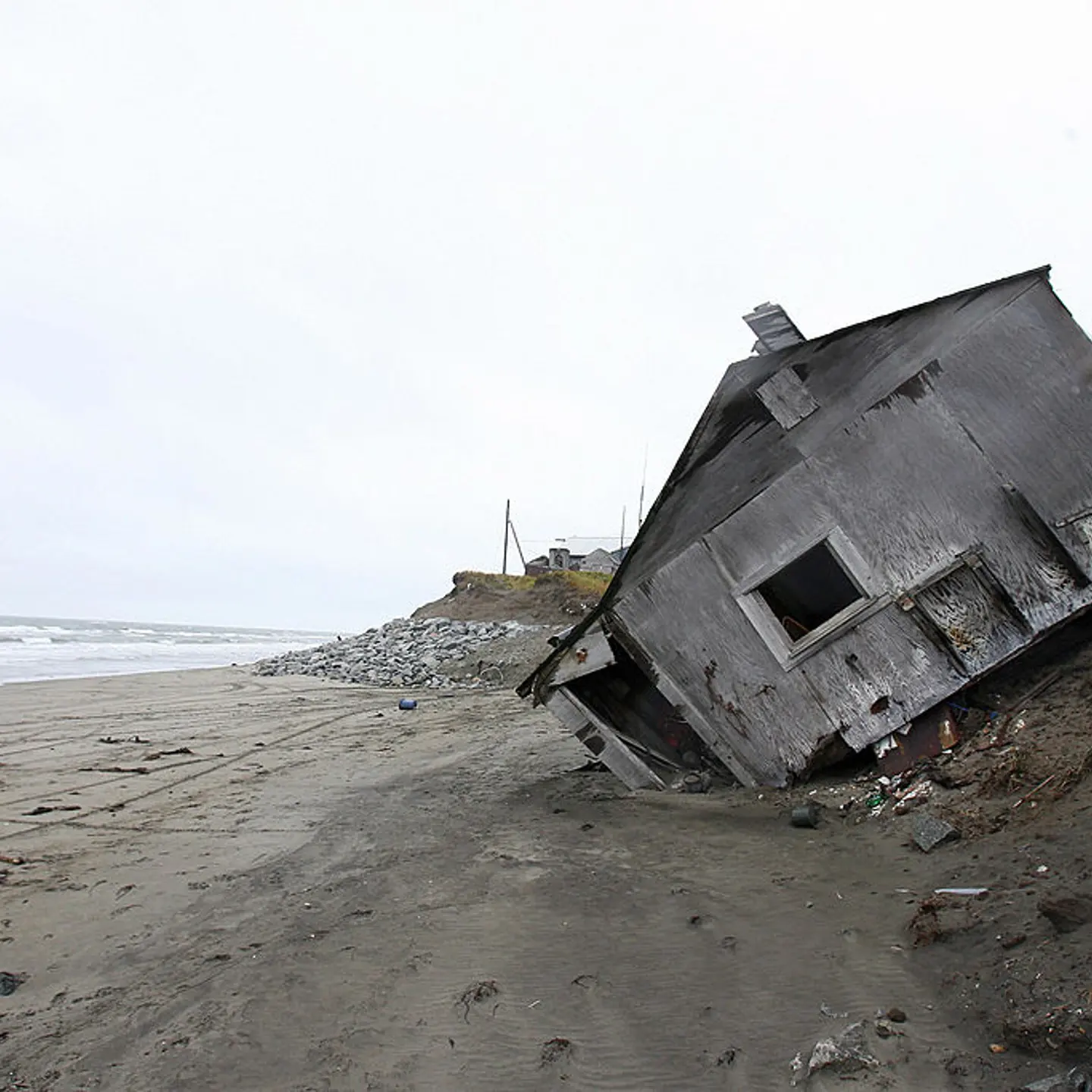A home destroyed by beach erosion lies o