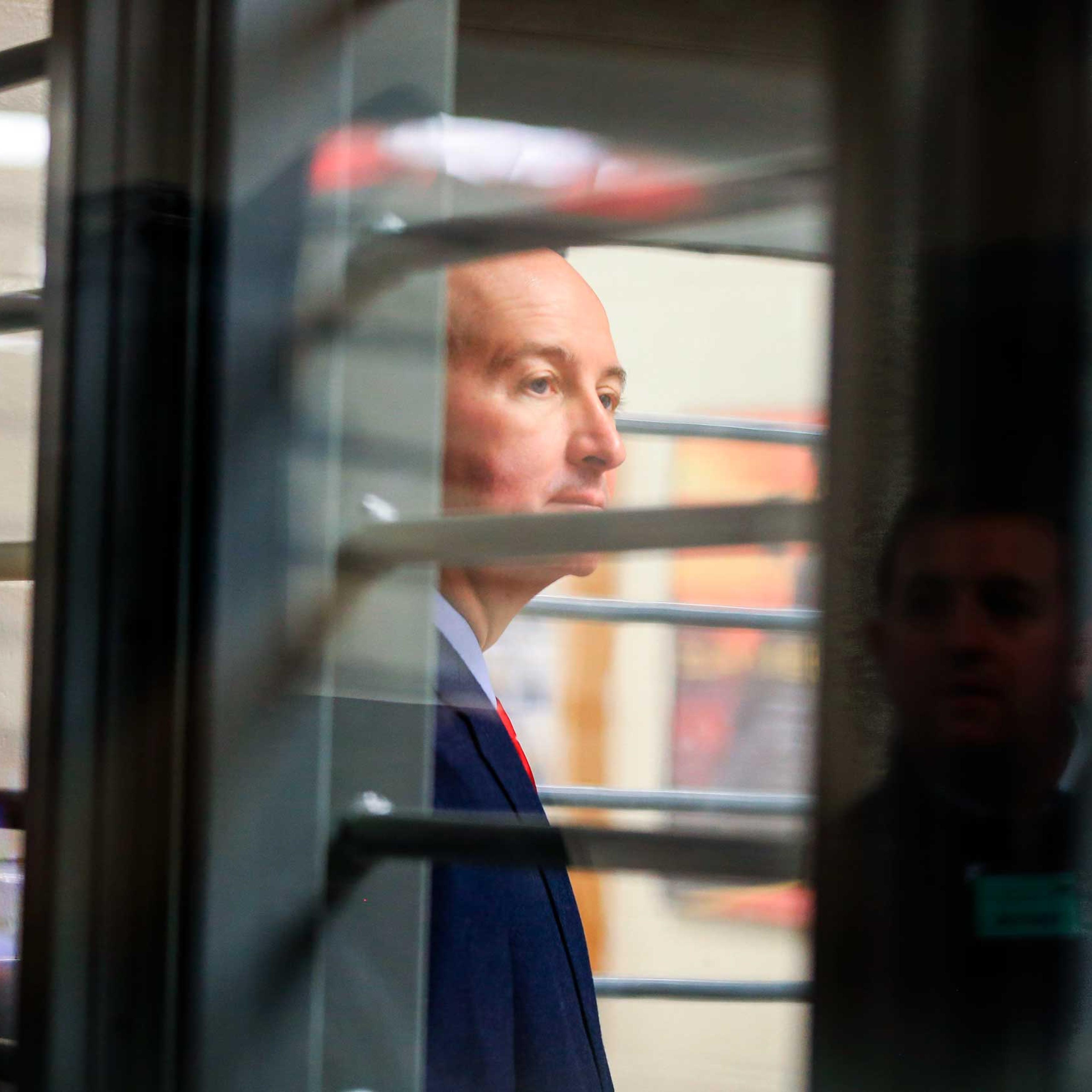 Nebraska Gov. Pete Ricketts is seen through bars during a tour of the Tecumseh State Correctional Institution in Tecumseh, Neb., on May 19, 2015.
