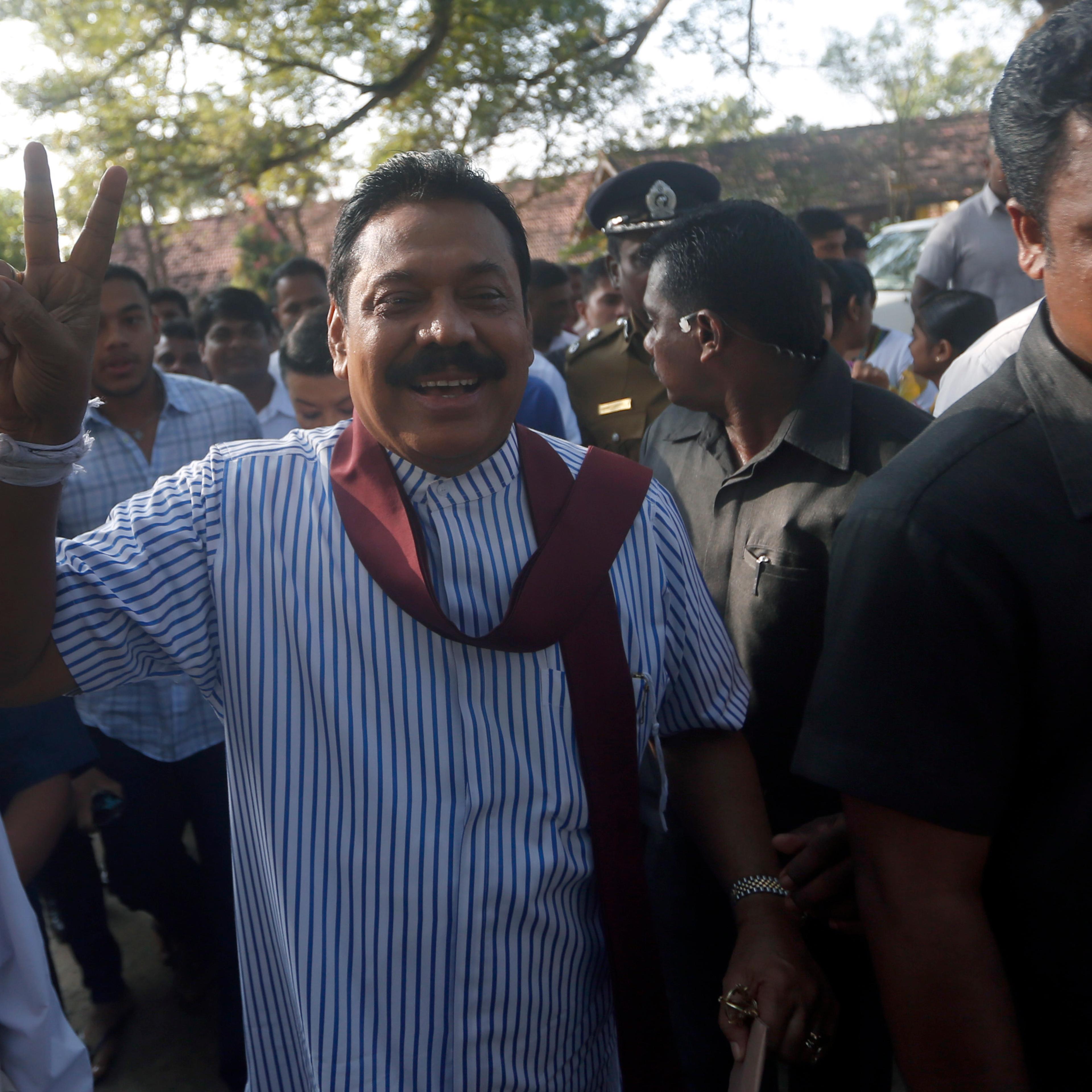 Sri Lanka's President Mahinda Rajapaksa gestures to the media after casting his vote for the presidential election, in Medamulana
