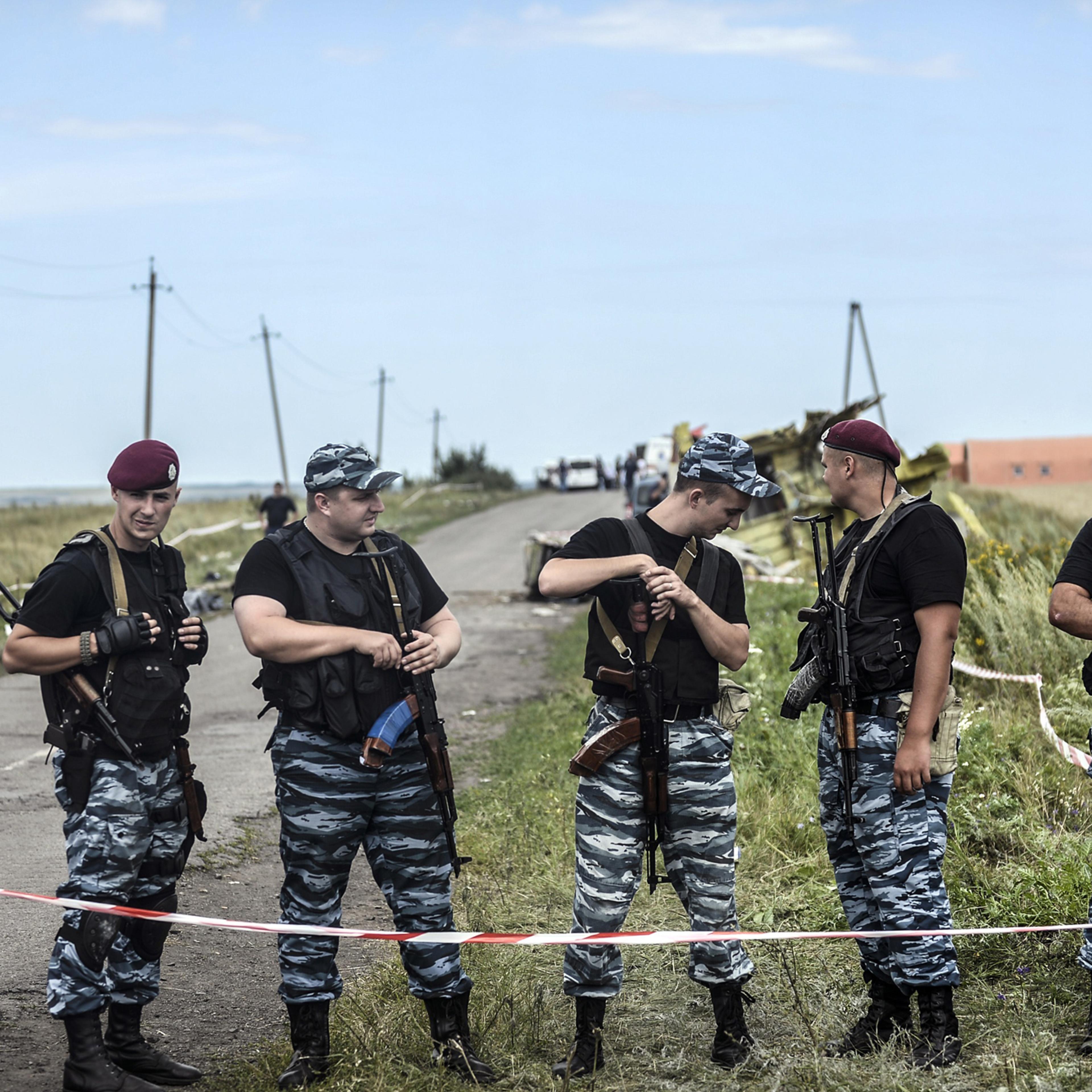 Armed pro-Russian separatists stand guard in front of the crash site of Malaysia Airlines Flight MH17, near the village of Grabove, in the region of Donetsk on July 20, 2014.