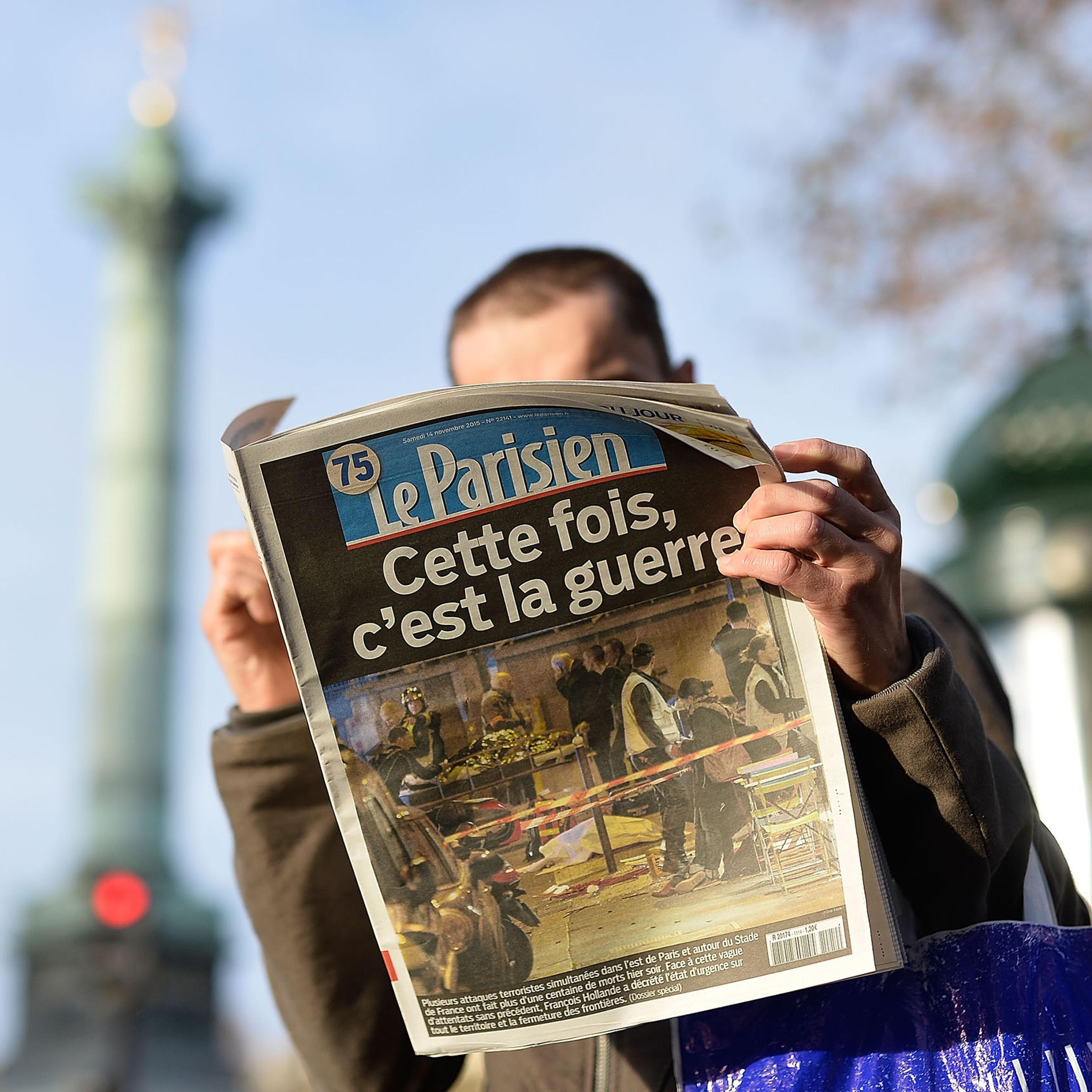A man reads a French newspaper after a terrorist attack in Paris on Nov. 14, 2015.