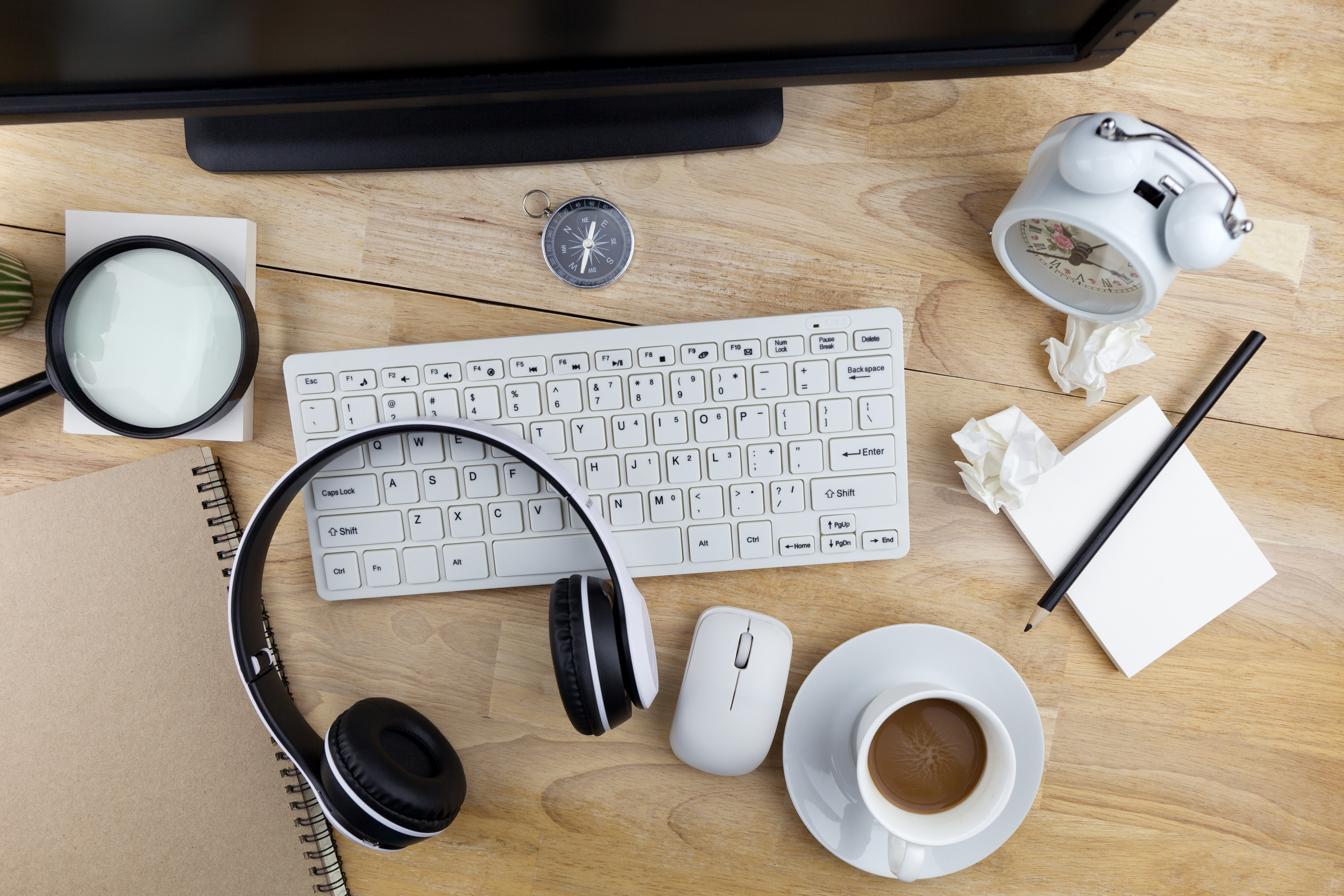 High Angle View Of Computer With Coffee And Clock On Desk