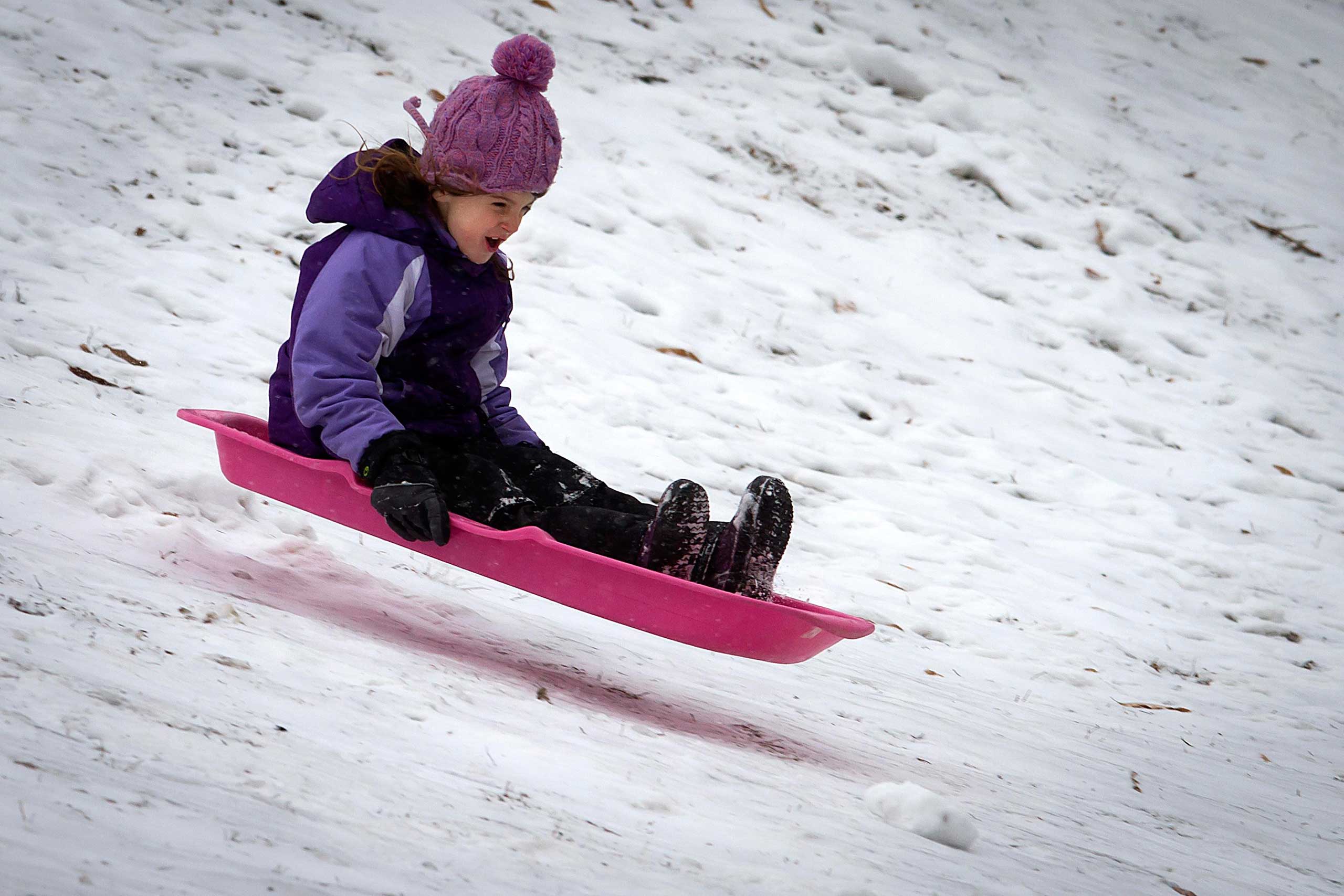 Children play in Central Park as it snows in the Manhattan borough of New York