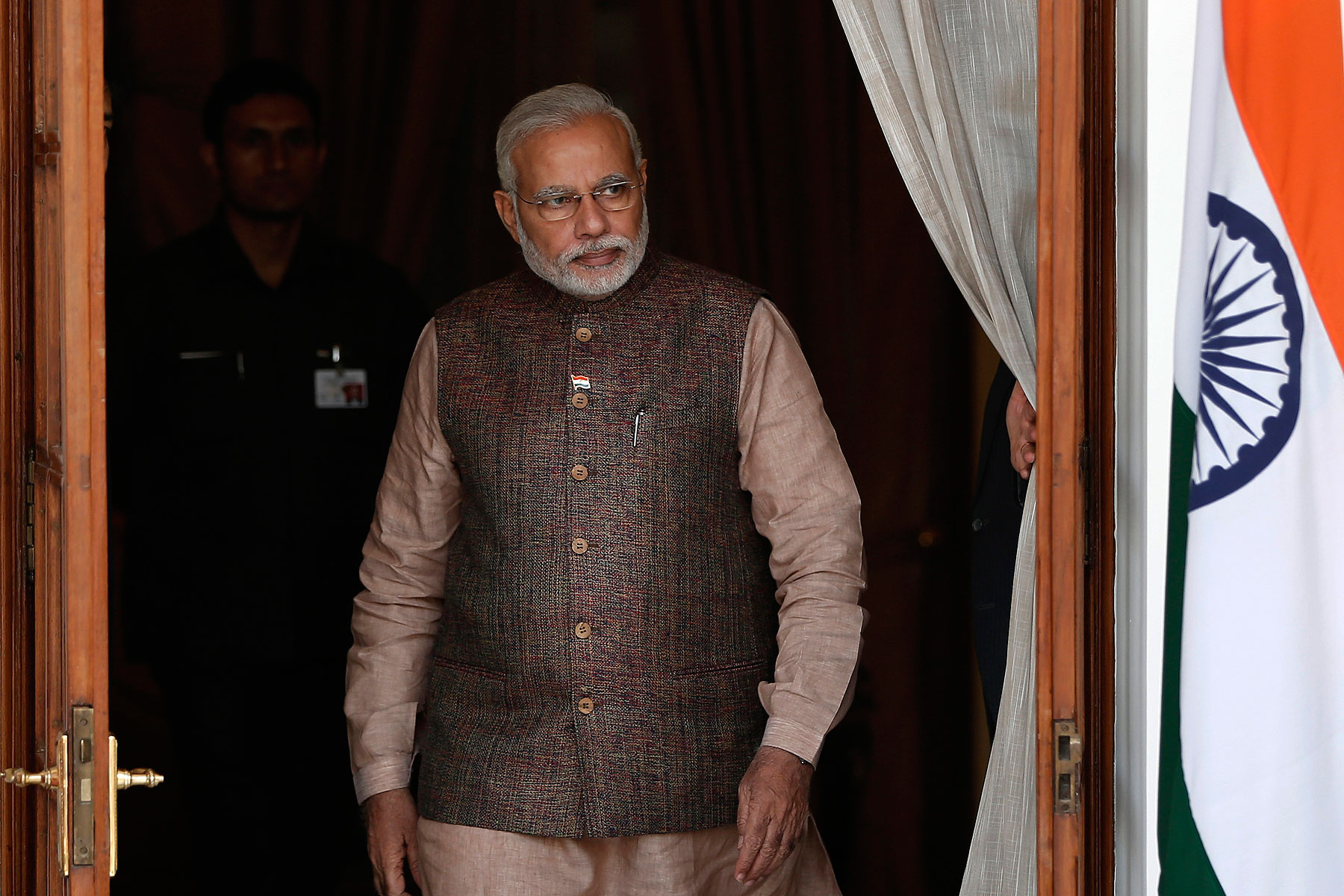 India's Prime Minister Narendra Modi comes out of a meeting room to receive his Bhutanese counterpart Tshering Tobgay before the start a bilateral meeting in New Delhi on May 27, 2014