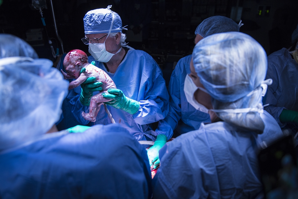 Dr. Robert T. Gunby Jr., holds up the baby for the mother to see.