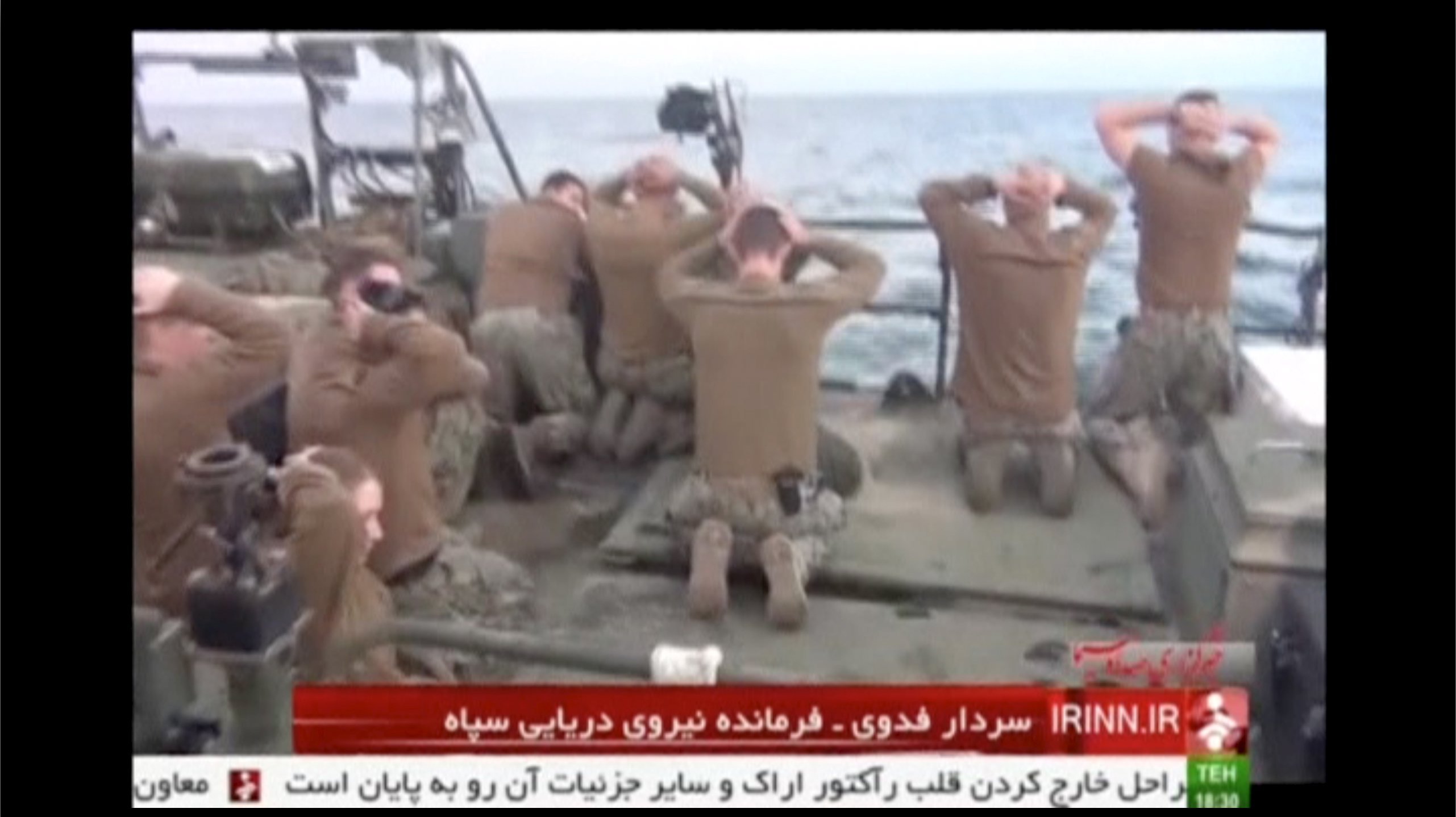 U.S. sailors are pictured on a boat with their hands on their heads at an unknown location