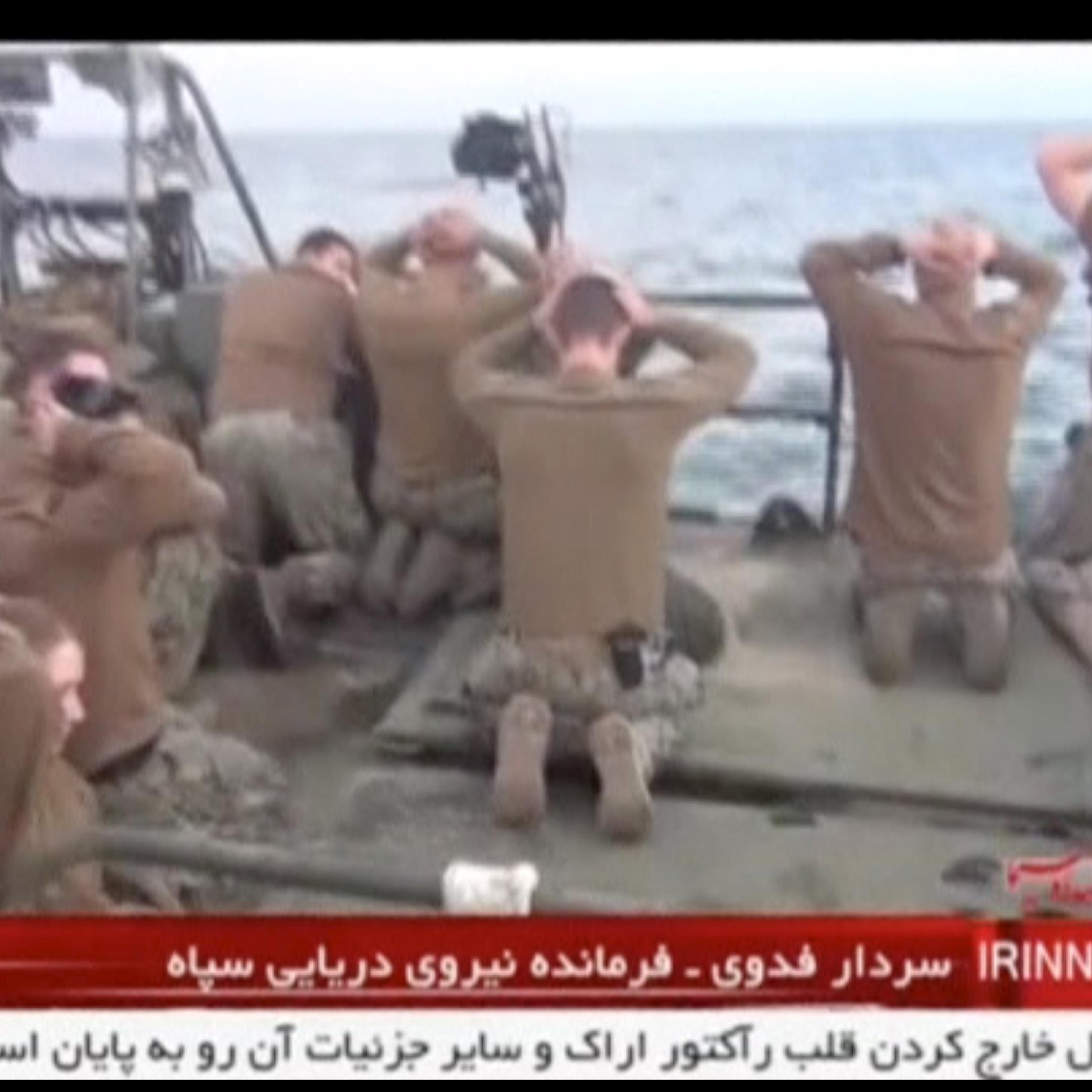 U.S. sailors are pictured on a boat with their hands on their heads at an unknown location