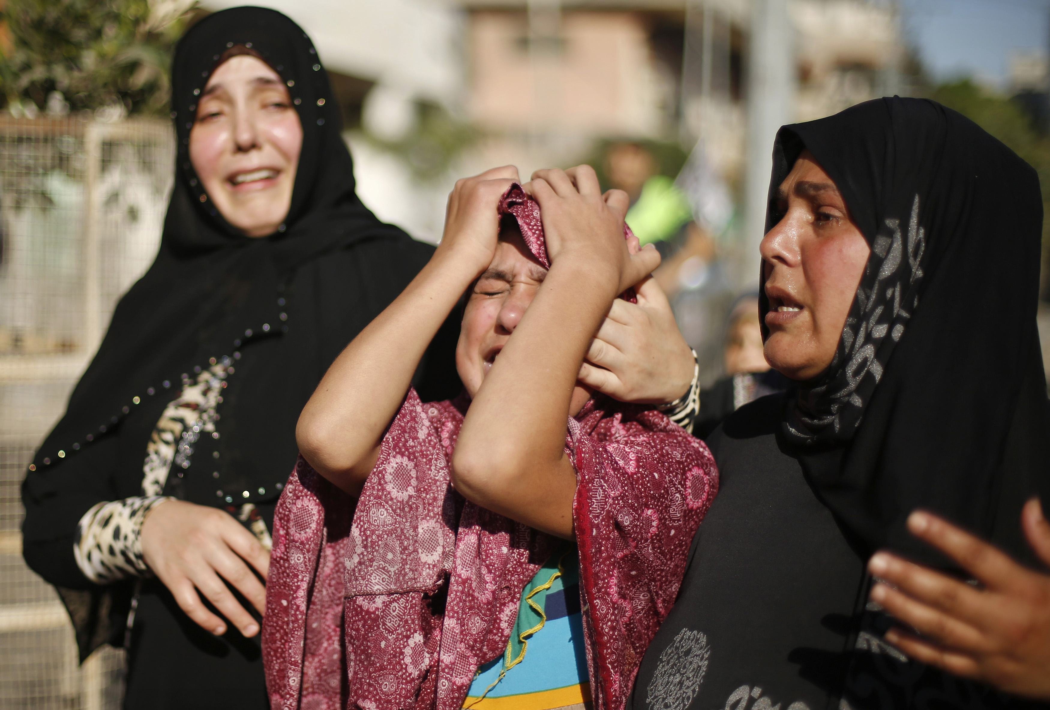 Sister of a Palestinian boy from Baker family, whom medics said was killed along with three other children from same family by a shell fired by Israeli naval gunboat, mourns during their funeral in Gaza City
