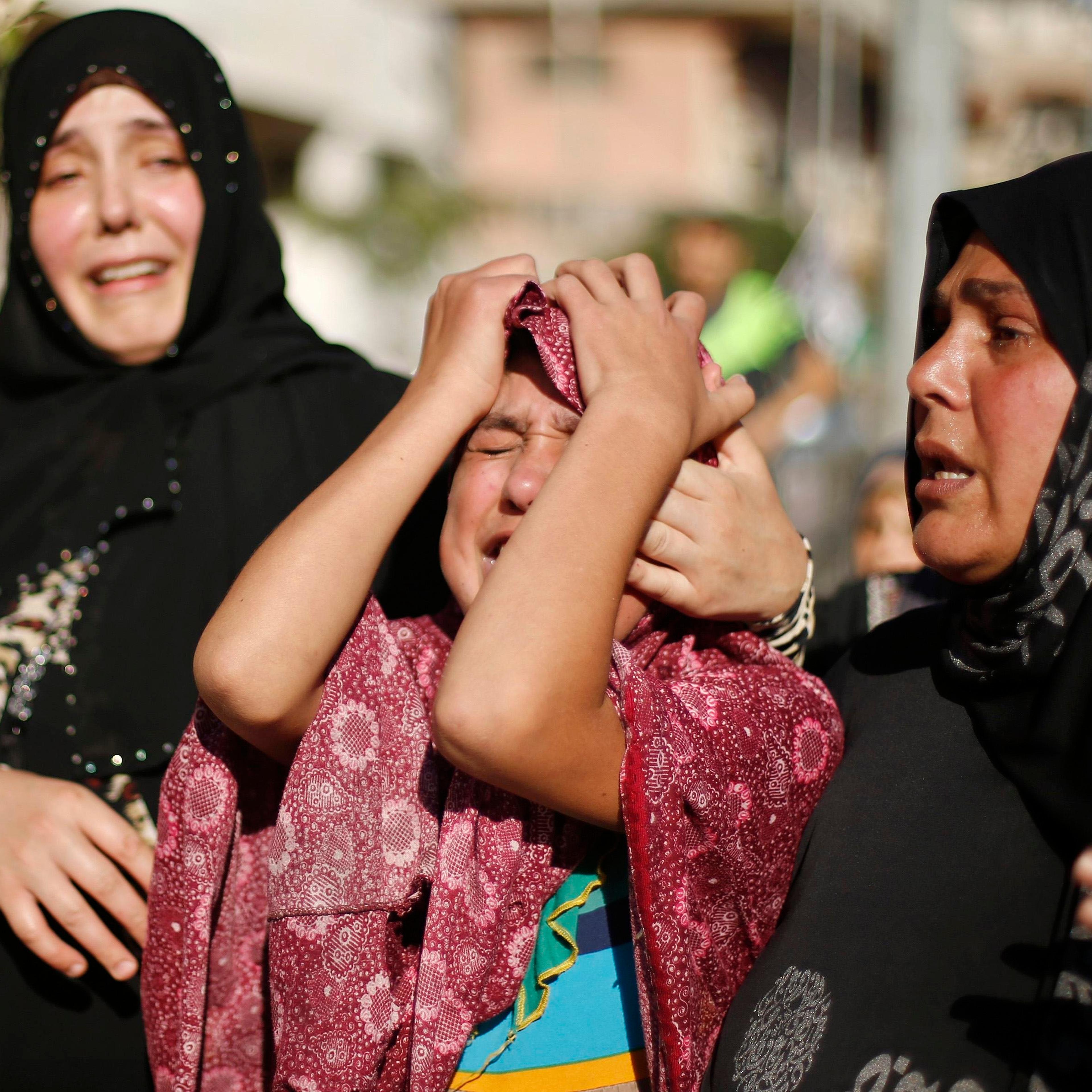 Sister of a Palestinian boy from Baker family, whom medics said was killed along with three other children from same family by a shell fired by Israeli naval gunboat, mourns during their funeral in Gaza City