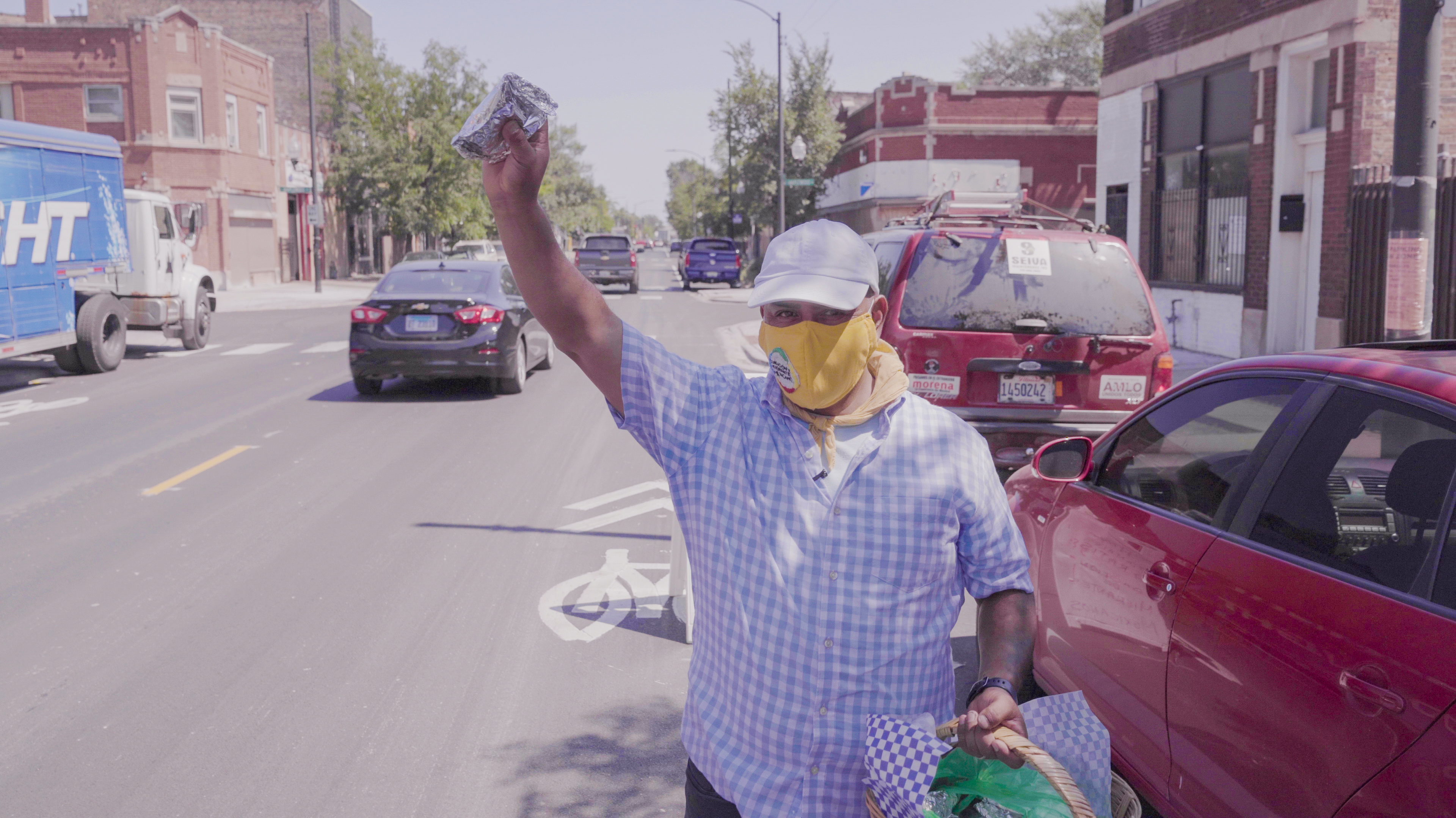 Alfonso Seiva, the president of the Coalition of Mexican Immigrants, hands out food in South Chicago in an episode of PBS/ Latino Public Broadcasting's "Latinos Are Essential." 