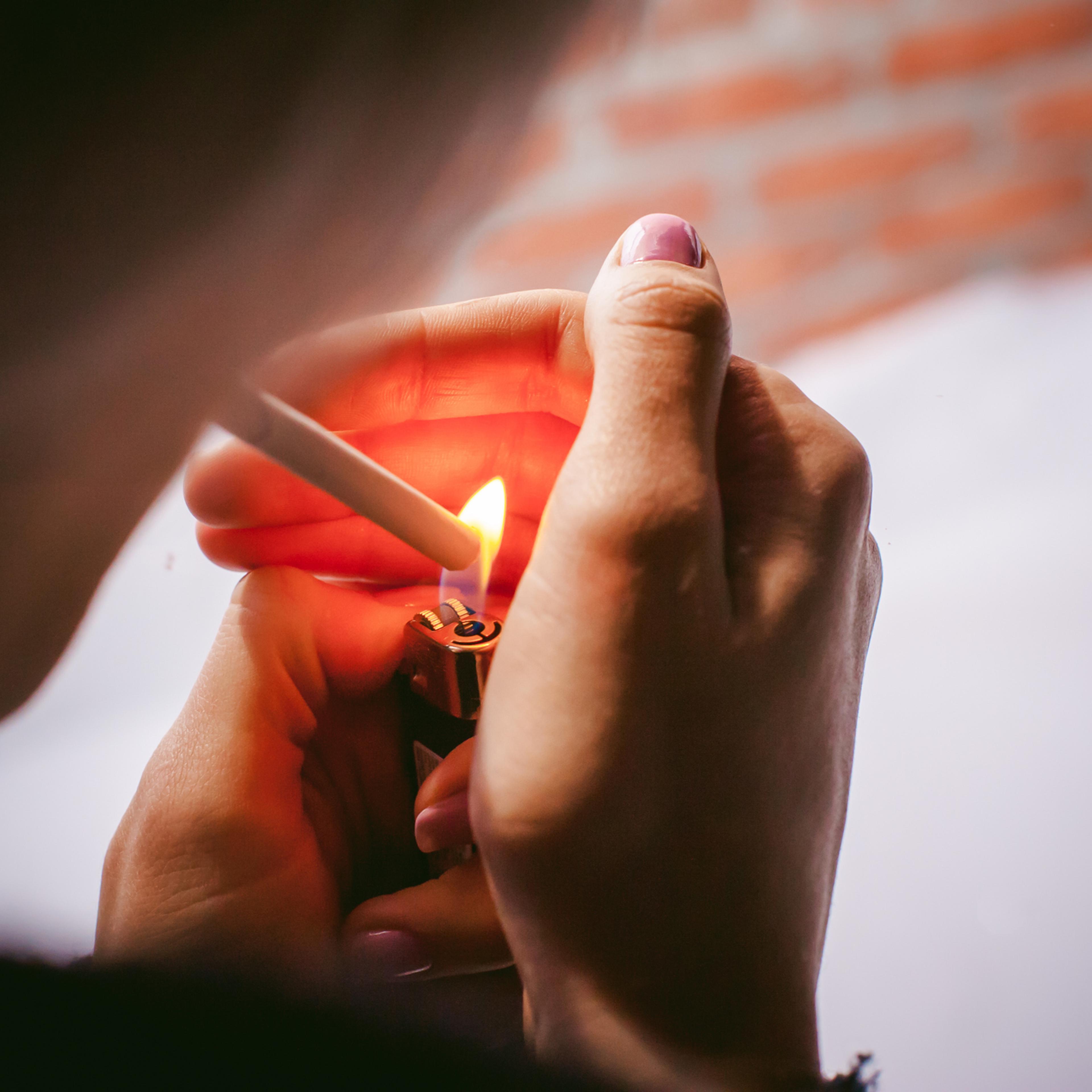 Close-Up Of Woman Igniting Cigarette