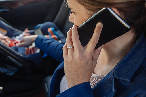 mother-newborn-car-cellphone
