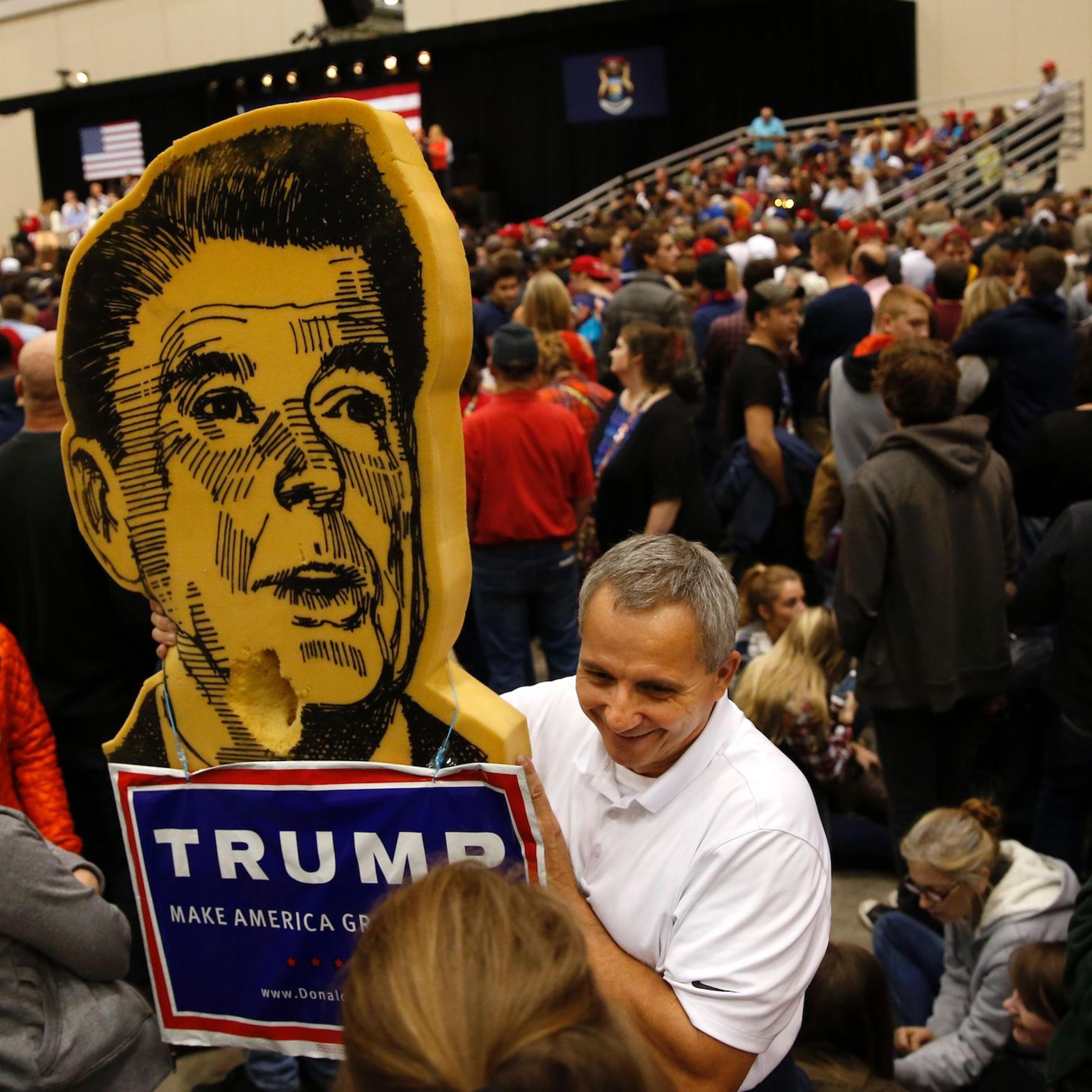 A man holds a Ronald Reagan-Donald Trump sign