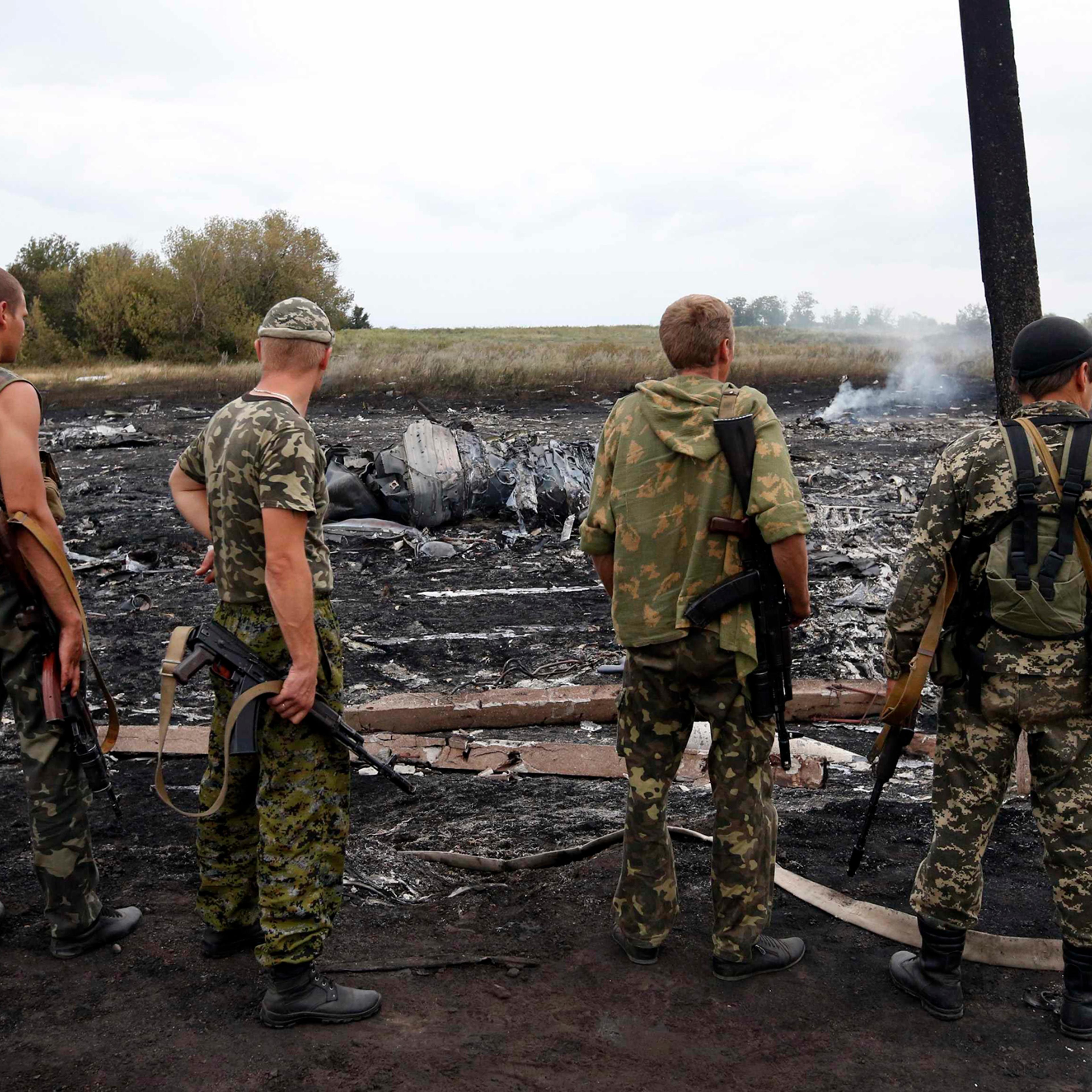Armed pro-Russian separatists stand at the site of a Malaysia Airlines Boeing 777 plane crash near the settlement of Grabovo in the Donetsk region, July 17, 2014.