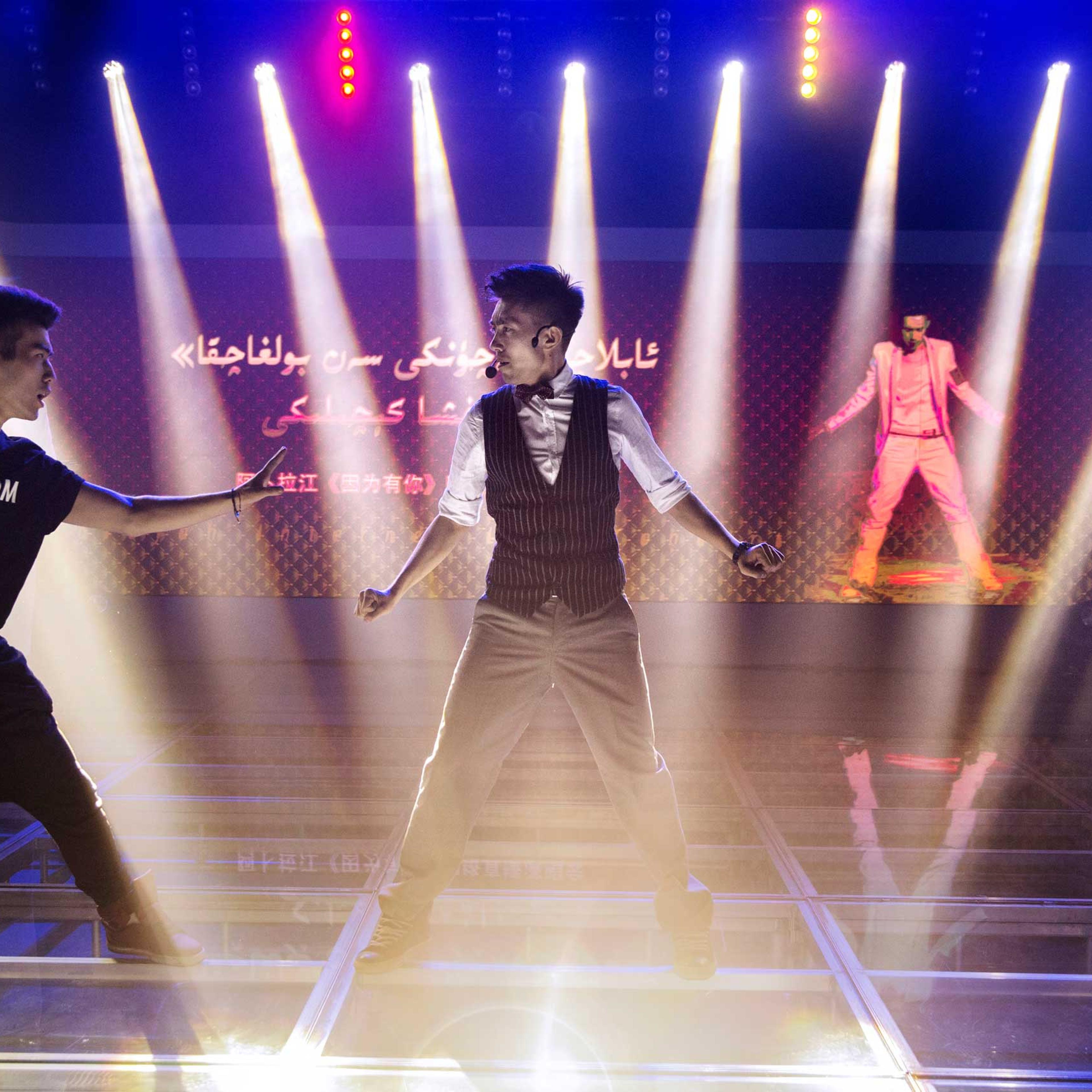 Ablajan performs on stage with his dancers at rehearsals for a planned live webcast concert scheduled for that afternoon in Urumqi, China on July 31st, 2014.