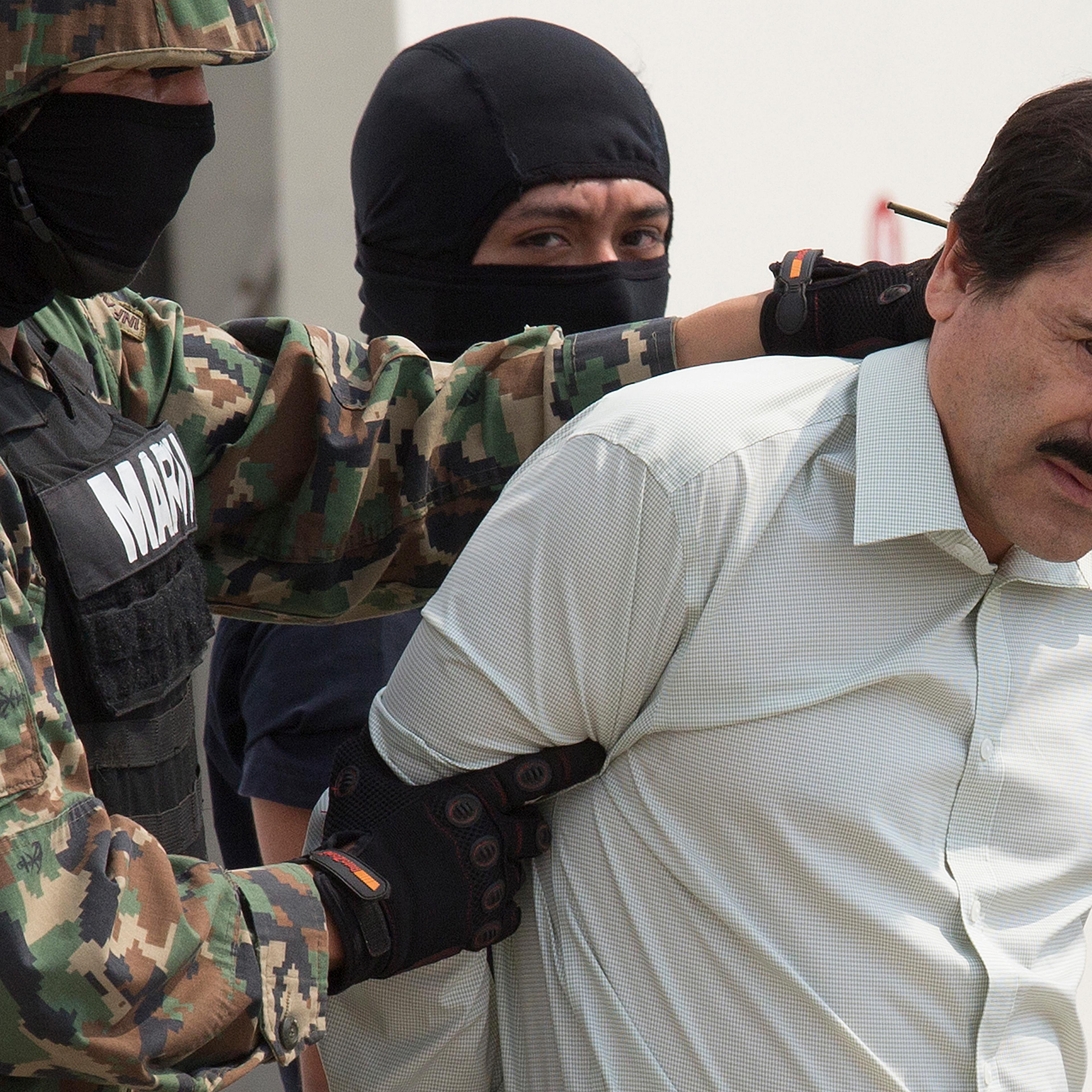 Drug trafficker Joaquin "El Chapo" Guzman is escorted to a helicopter by Mexican security forces at Mexico's International Airport in Mexico city on Feb. 22, 2014.