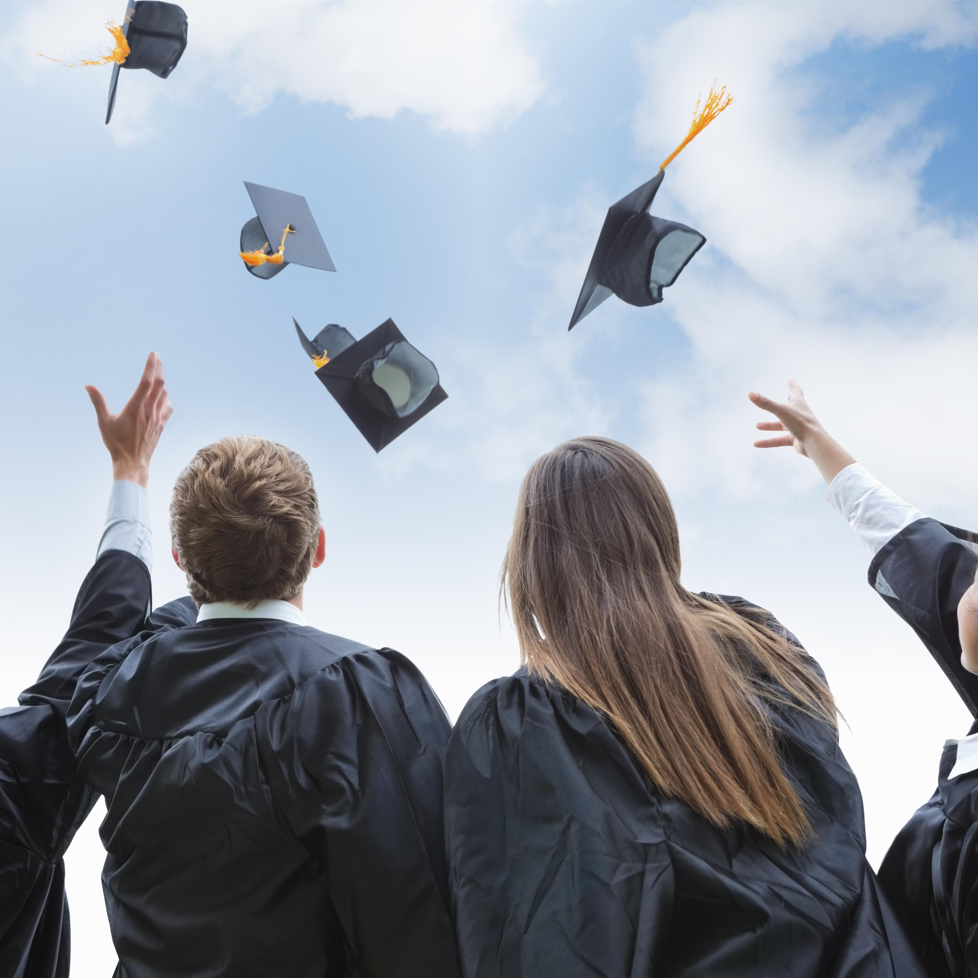 Excited group of college graduates throwing their hats in celebration